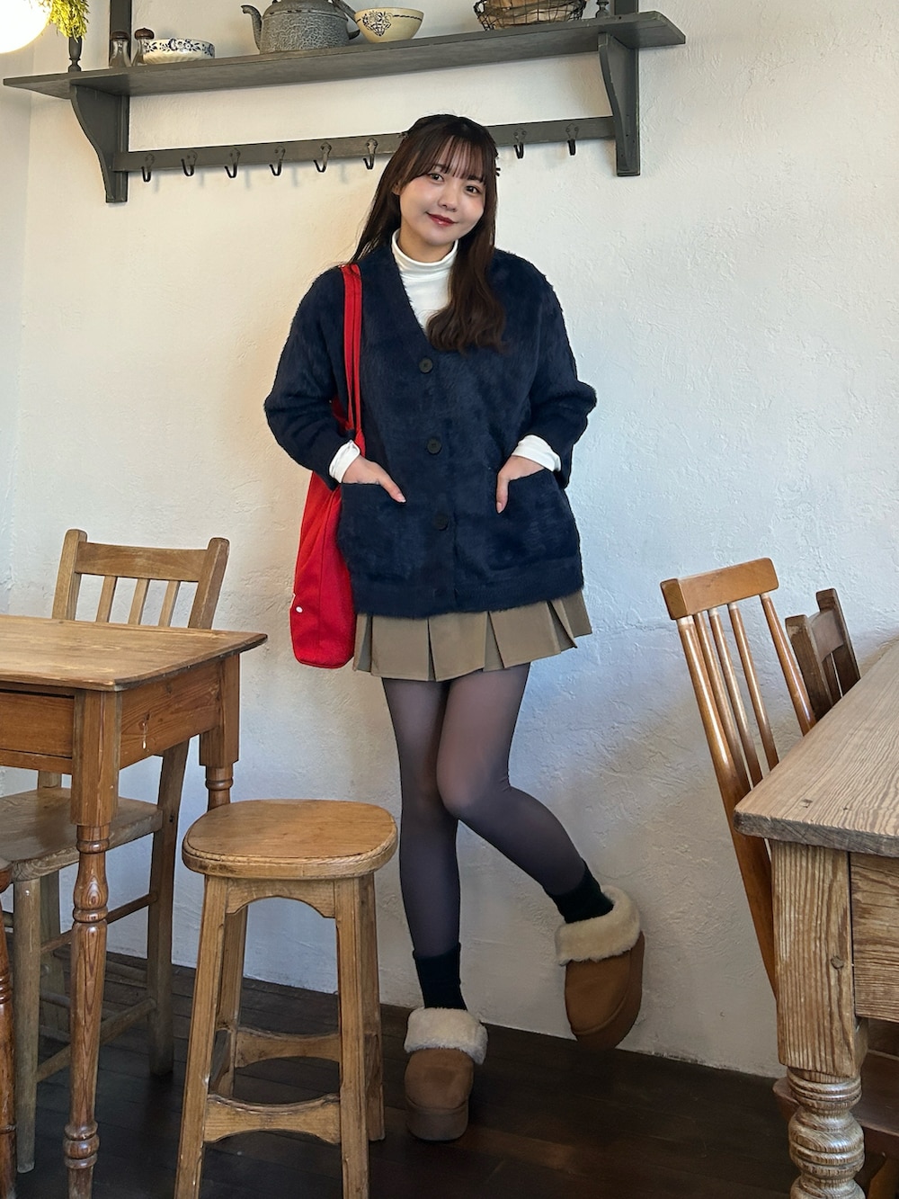 ブルー系のカーディガン/ボレロ、ホワイト系のトップス、ベージュ系のスカートを着用したレディースの冬コーディネートの4枚目の写真