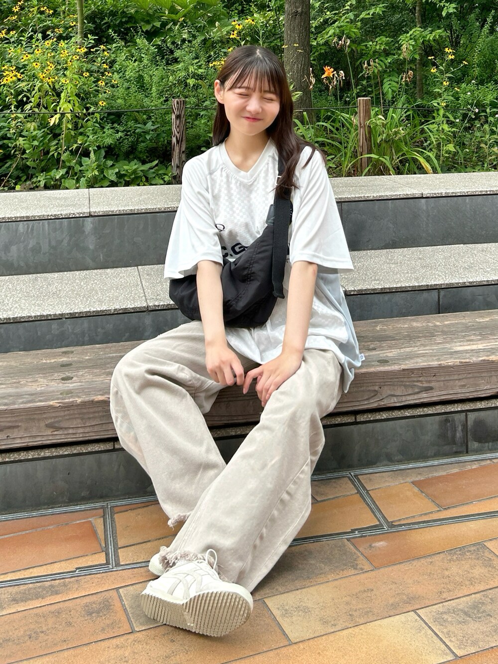 ホワイト系のTシャツ/カットソー、ブラック系のショルダーバッグ、ベージュ系のデニムパンツを着用したレディースの夏コーディネートの5枚目の写真