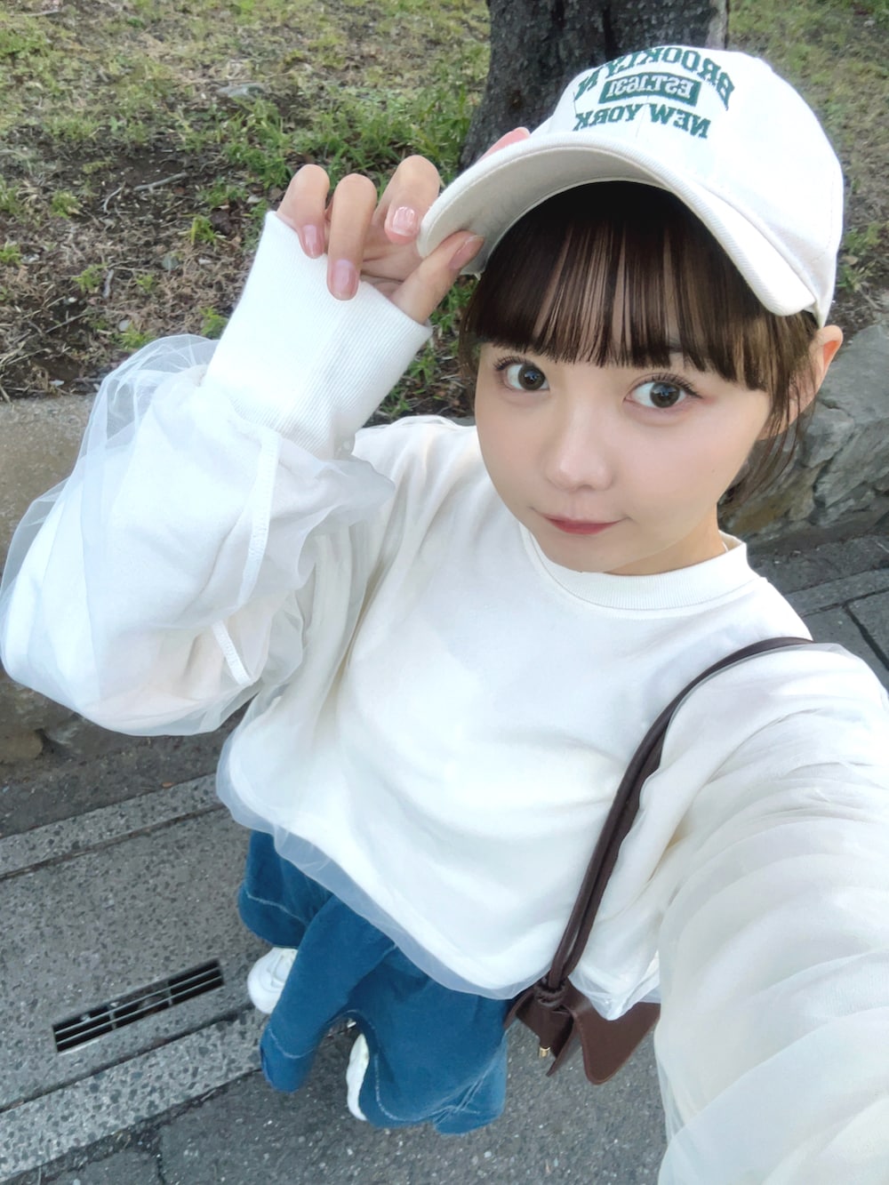 ホワイト系のスウェット、ブルー系のデニムスカート、ホワイト系のスニーカーを着用したレディースの春コーディネートの5枚目の写真