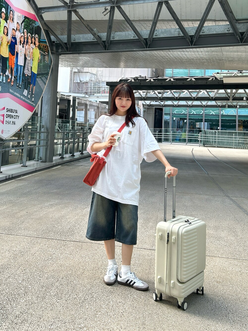 ホワイト系のTシャツ/カットソー、ブルー系のデニムパンツ、ホワイト系のスニーカーを着用したレディースの夏コーディネートの5枚目の写真