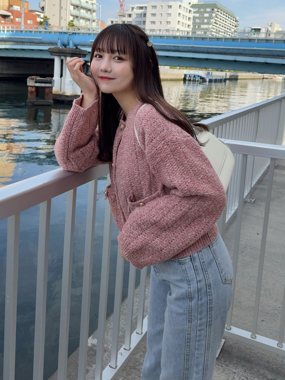 レッド系のカーディガン/ボレロ、ブラウン系のステンカラーコート、ブルー系のデニムパンツを着用したレディースの冬コーディネートの5枚目の写真