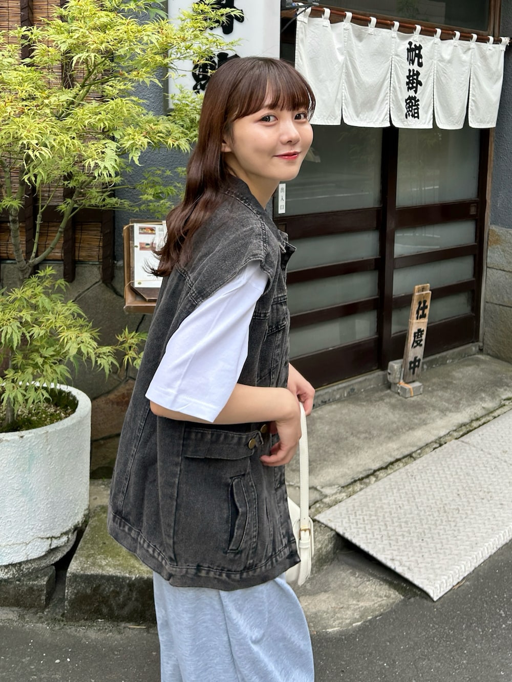 ホワイト系のスニーカー、ホワイト系のハンドバッグ、グレー系のスウェットパンツを着用したレディースの秋コーディネートの3枚目の写真