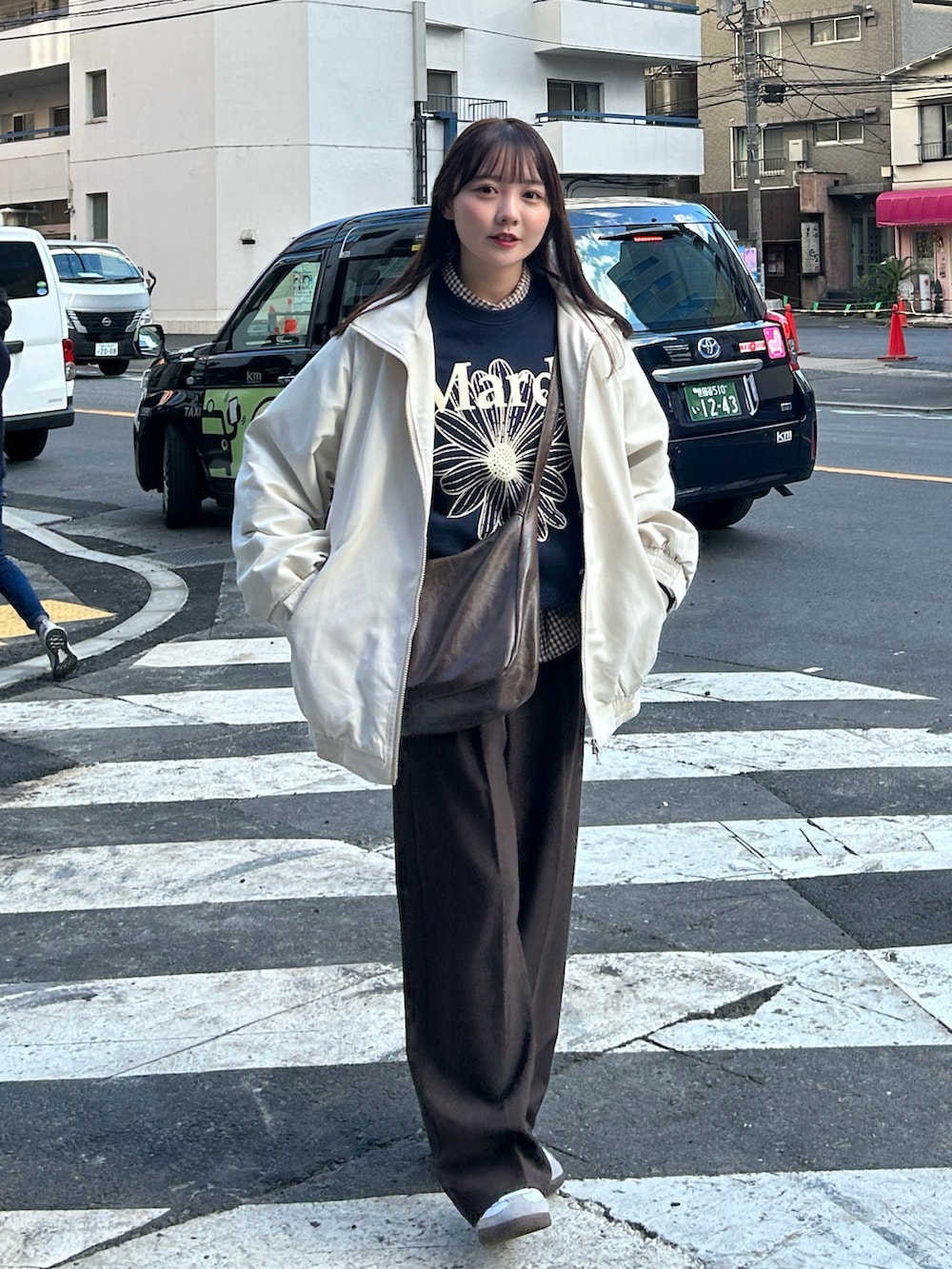 ブラウン系のシャツ/ブラウス、ブラウン系のショルダーバッグ、ベージュ系のブルゾンを着用したレディースの冬コーディネートの4枚目の写真