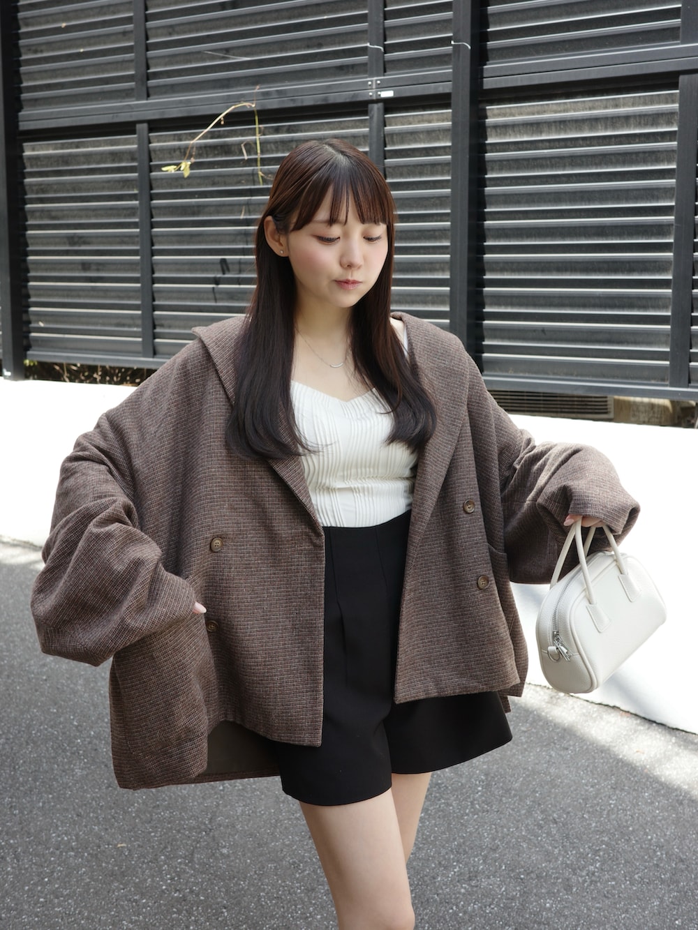 ホワイト系のキャミソール、ブラック系のその他パンツ、ホワイト系のショルダーバッグを着用したレディースの夏コーディネートの3枚目の写真