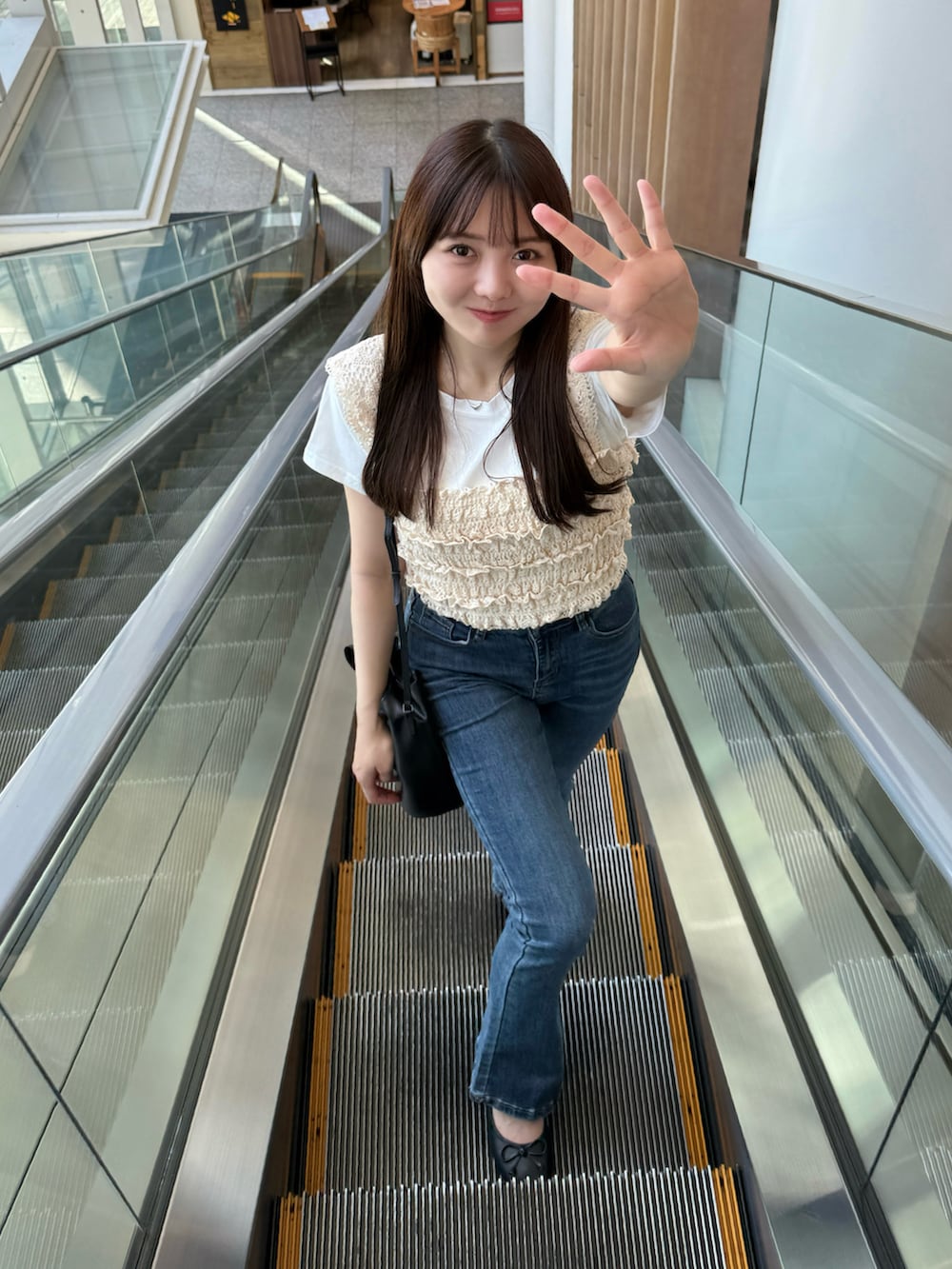 ホワイト系のTシャツ/カットソー、ベージュ系のベスト、ブルー系のデニムパンツを着用したレディースの夏コーディネートの2枚目の写真