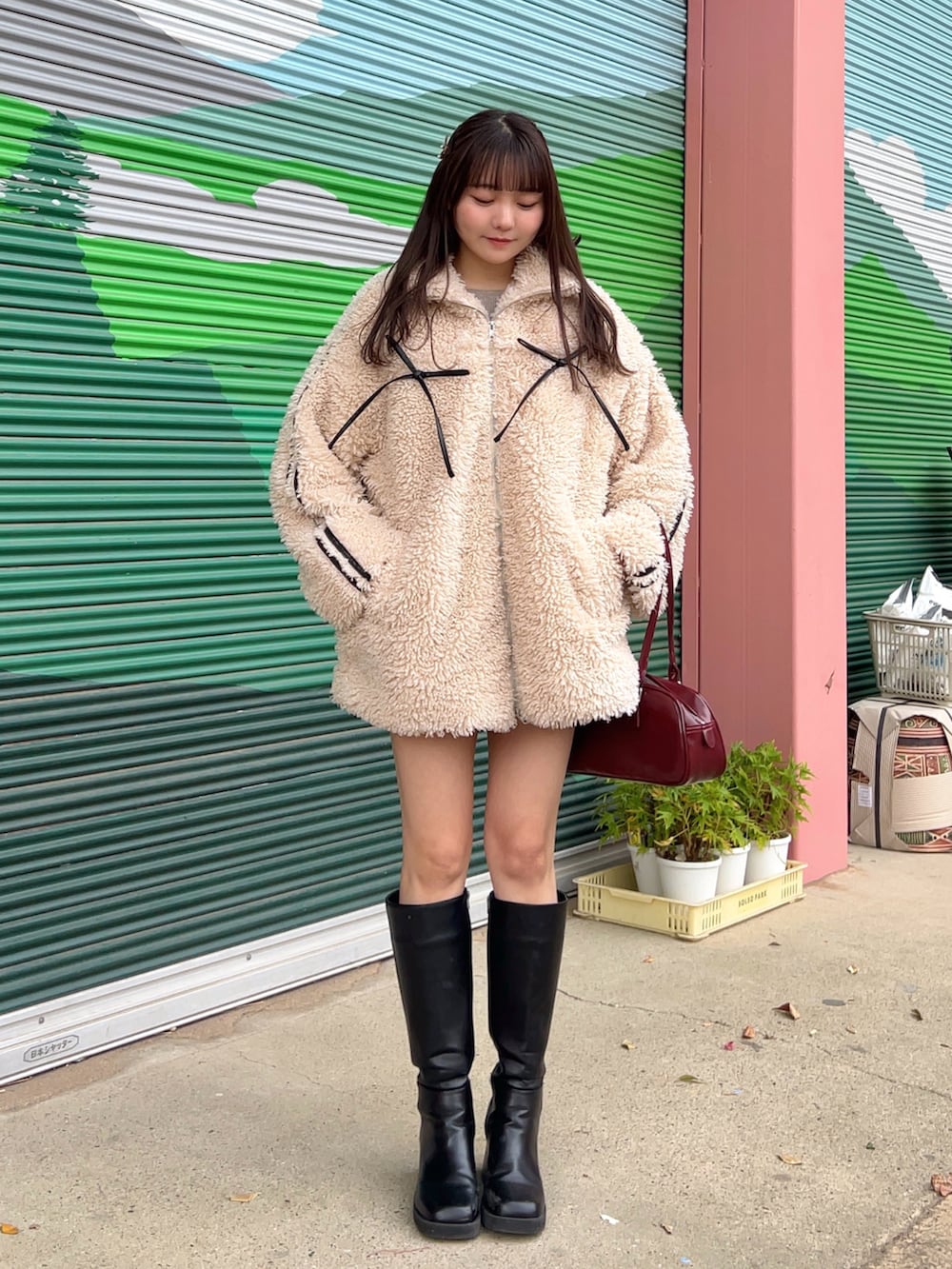 ブラウン系のニット/セーター、ブラウン系のその他パンツ、レッド系のボストンバッグを着用したレディースの冬コーディネートの2枚目の写真