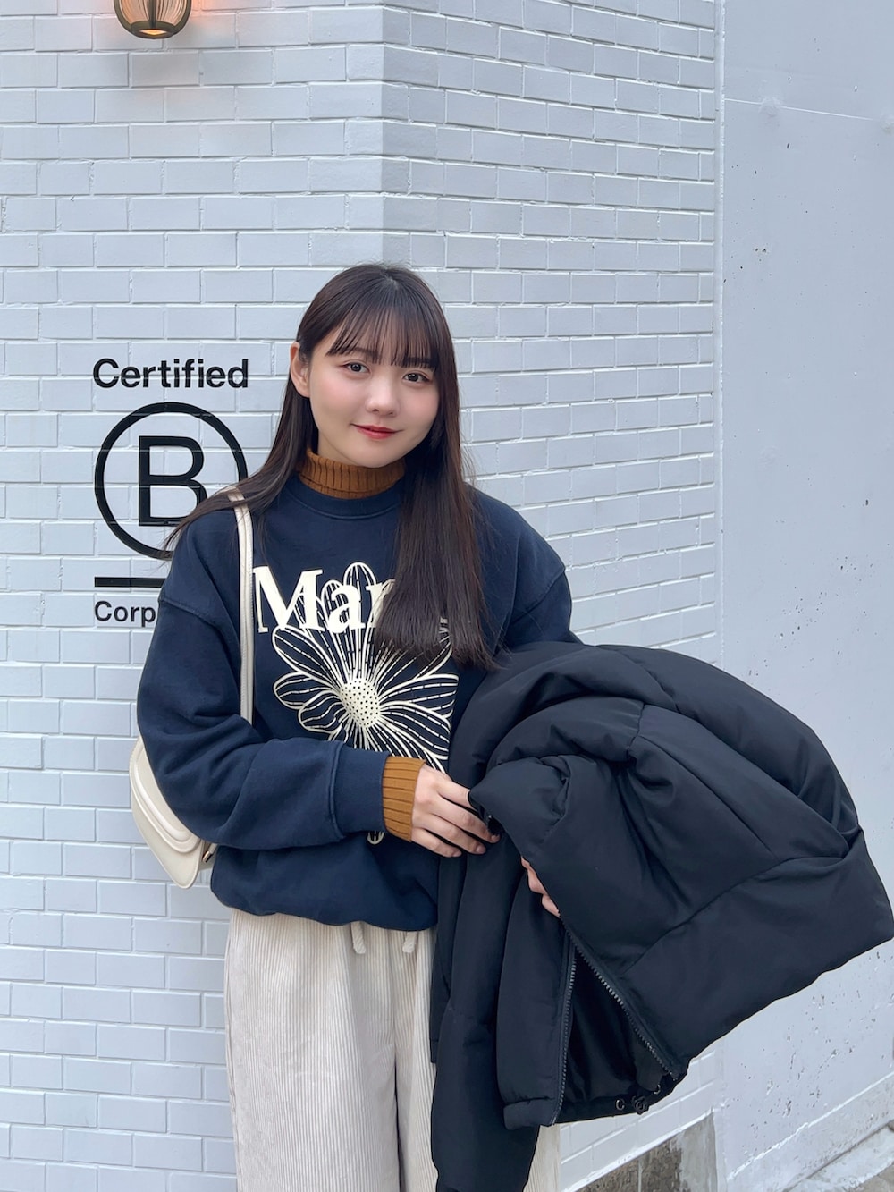 ブラック系のダウンジャケット/コート、ホワイト系のパンツ、イエロー系のブーツを着用したレディースの冬コーディネートの4枚目の写真