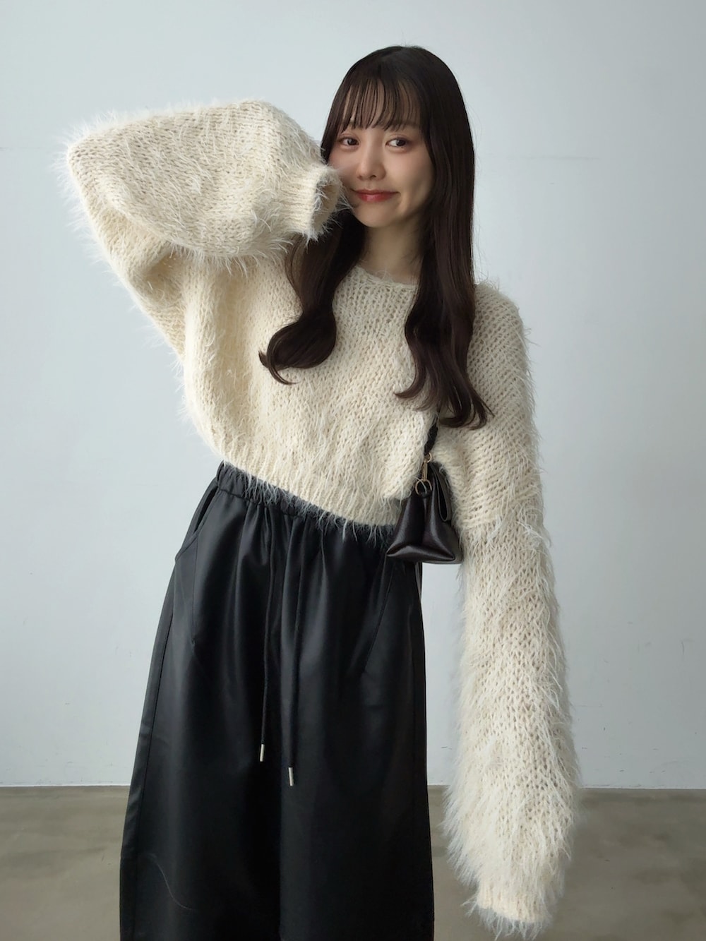 ベージュ系のニット/セーター、ブラック系のその他パンツ、ブラウン系のショルダーバッグを着用したレディースの秋コーディネートの5枚目の写真