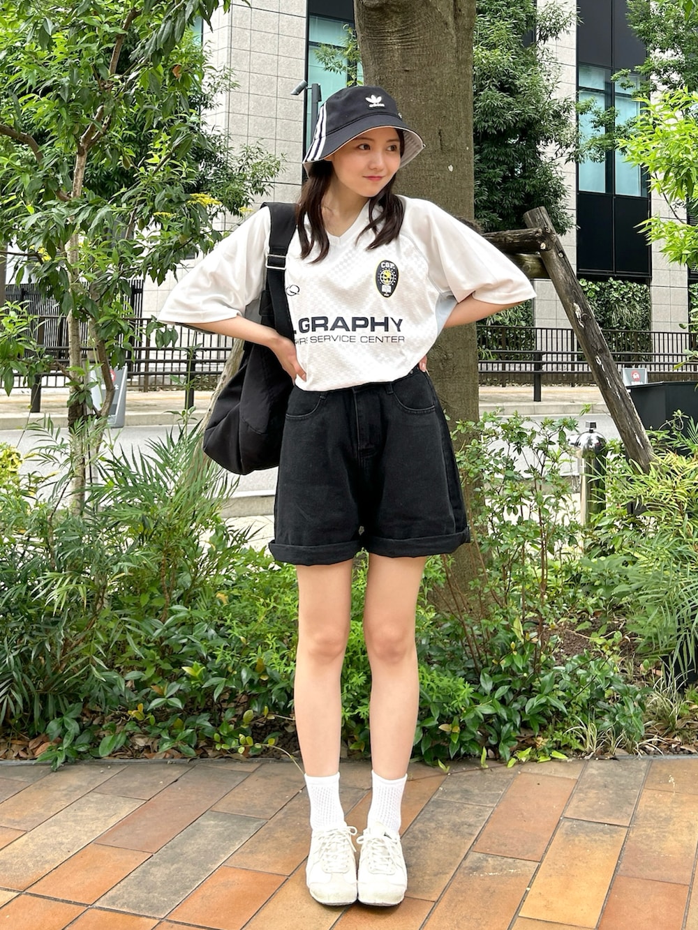 ブラック系のショルダーバッグ、ホワイト系のTシャツ/カットソー、ブラック系のデニムパンツを着用したレディースの夏コーディネートの4枚目の写真