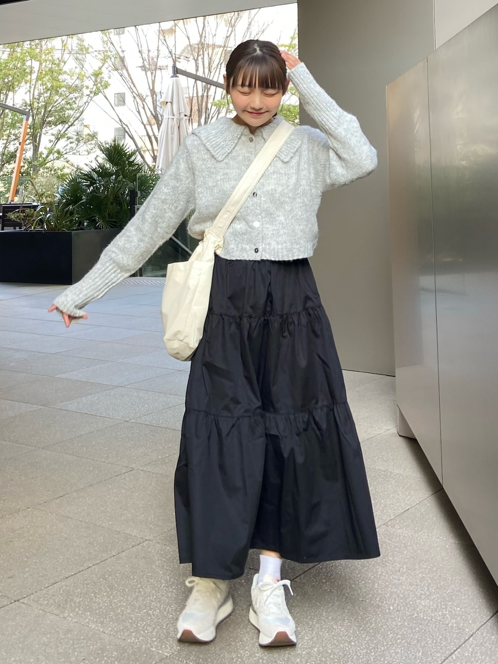 ブラック系のワンピース、グレー系のニット/セーター、ベージュ系のショルダーバッグを着用したレディースの春コーディネートの2枚目の写真