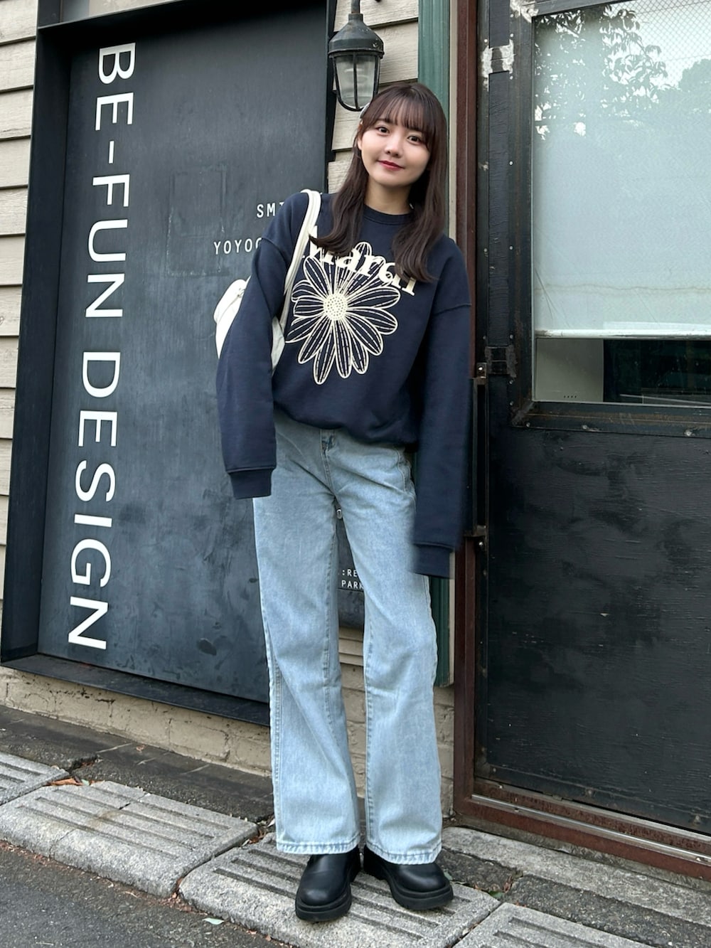 ホワイト系のダウンジャケット/コート、ブルー系のスウェット、ホワイト系のバッグを着用したレディースの冬コーディネートの5枚目の写真