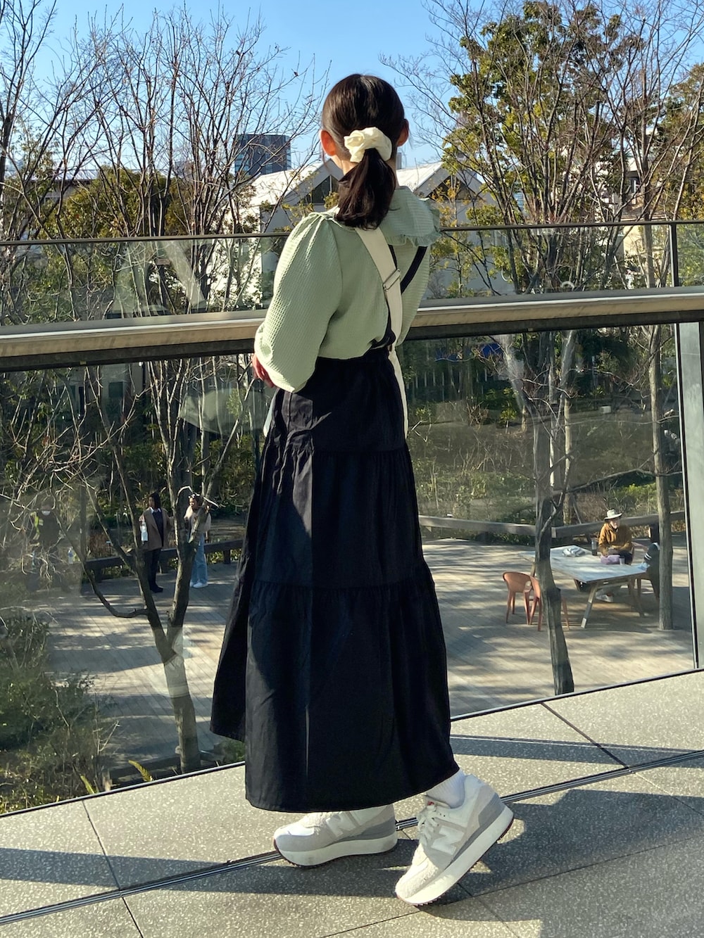 ブラック系のワンピース、ベージュ系のショルダーバッグ、グリーン系のシャツ/ブラウスを着用したレディースの春コーディネートの3枚目の写真