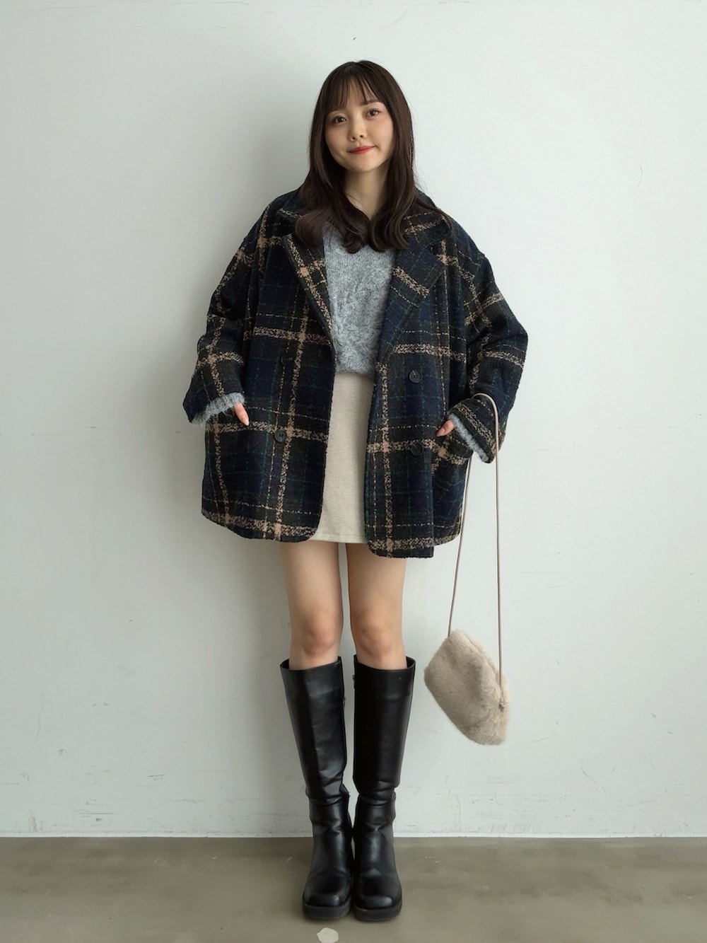 グレー系のニット/セーター、ホワイト系のスカート、ホワイト系のショルダーバッグを着用したレディースの冬コーディネートの5枚目の写真