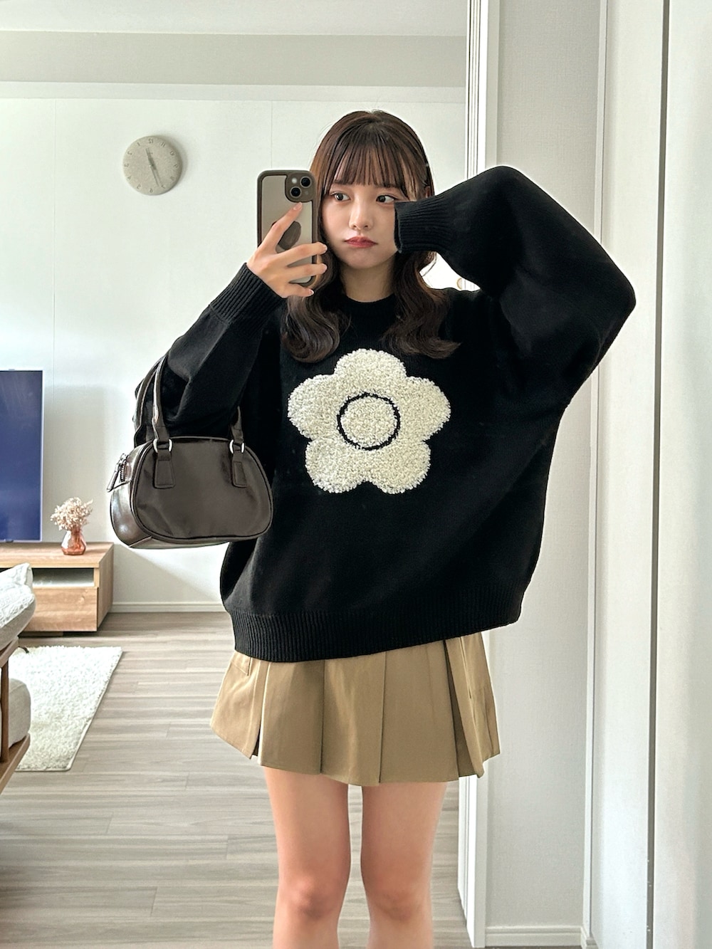 ブラウン系のハンドバッグ、ベージュ系のブーツ、ベージュ系のスカートを着用したレディースの秋コーディネートの3枚目の写真