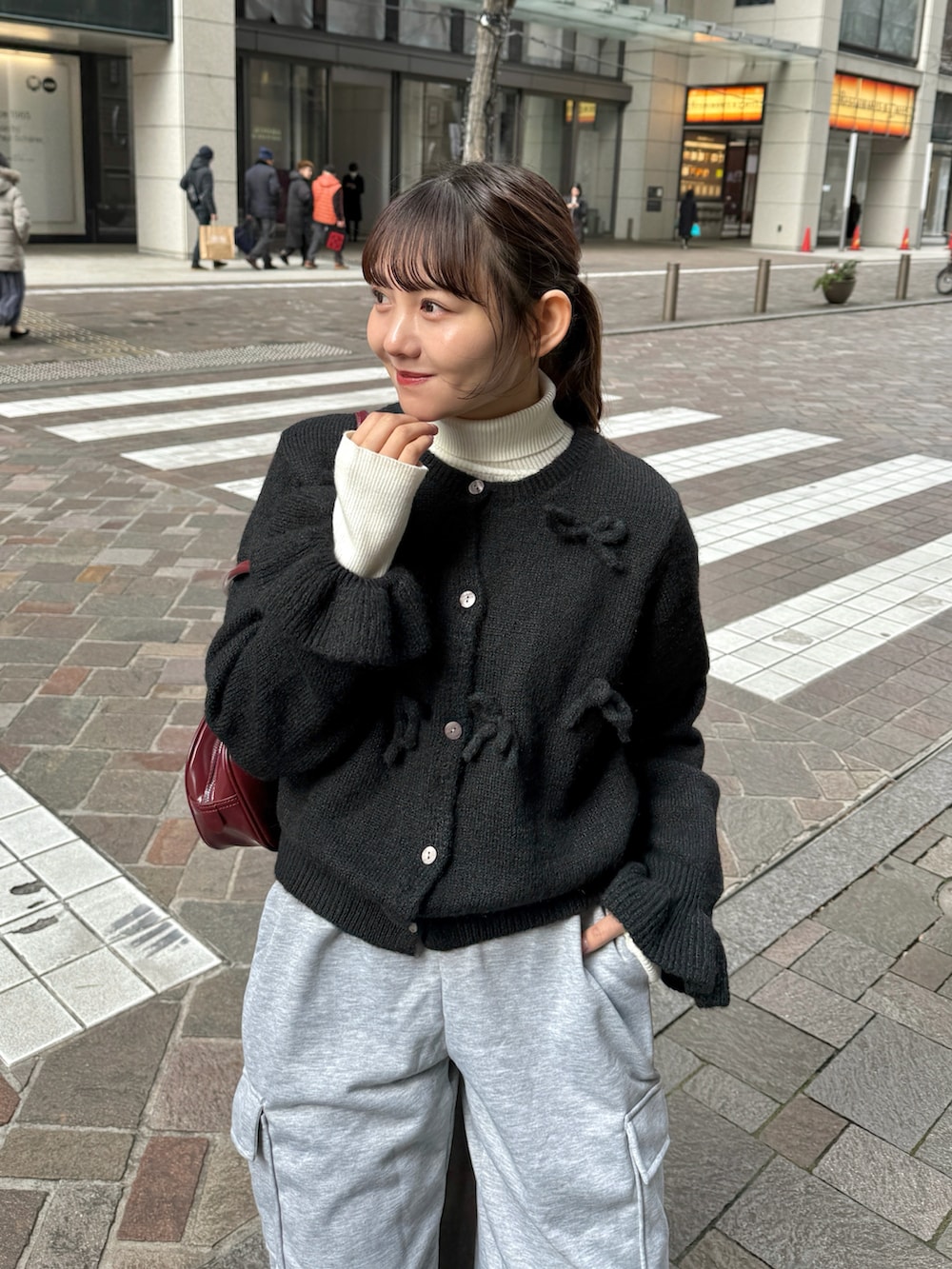 ブラック系のニット/セーター、ホワイト系のニット/セーター、レッド系のボストンバッグを着用したレディースの冬コーディネートの2枚目の写真