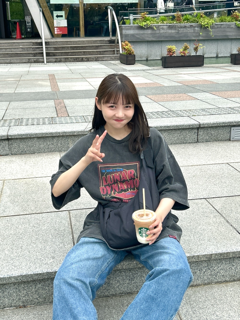 ブラック系のショルダーバッグ、ブルー系のデニムパンツ、ホワイト系のスニーカーを着用したレディースの夏コーディネートの4枚目の写真