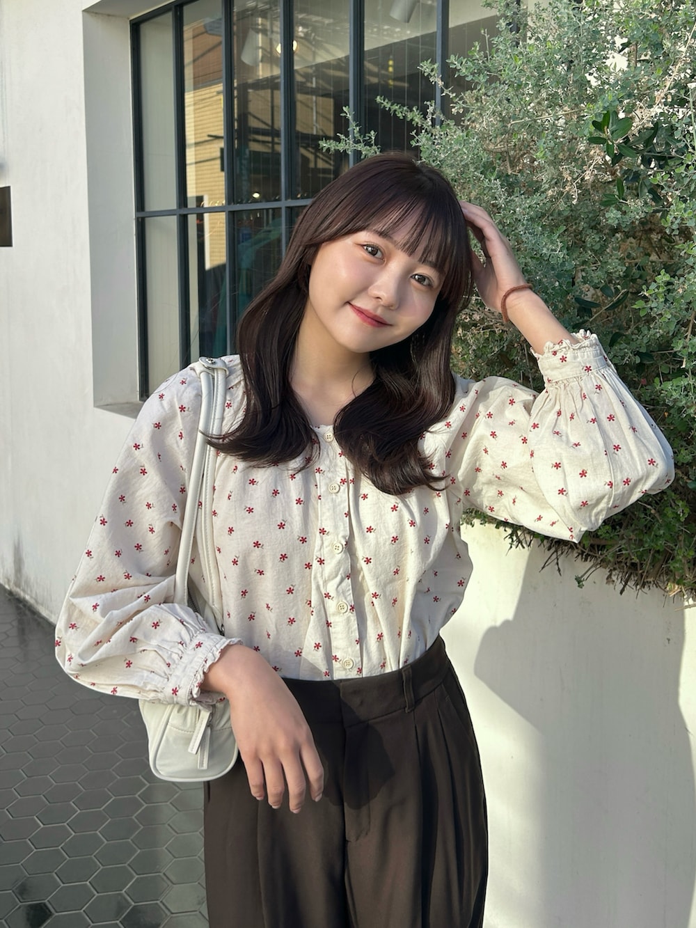 レッド系のシャツ/ブラウス、ホワイト系のバッグ、グレー系のスニーカーを着用したレディースの秋コーディネートの4枚目の写真