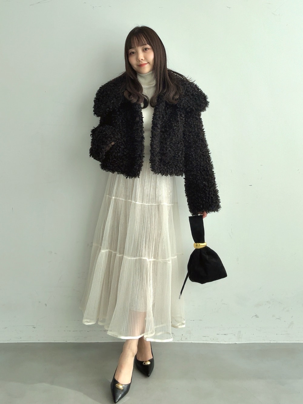 ホワイト系のTシャツ/カットソー、ブラック系のブルゾン、ホワイト系のスカートを着用したレディースの冬コーディネートの4枚目の写真