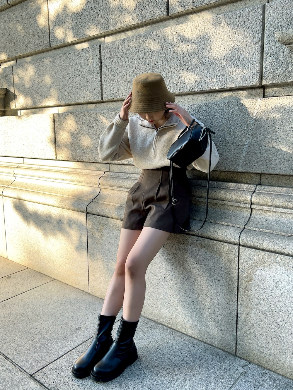 ホワイト系のブルゾン、ベージュ系のニット/セーター、ブラウン系のその他パンツを着用したレディースの冬コーディネートの2枚目の写真