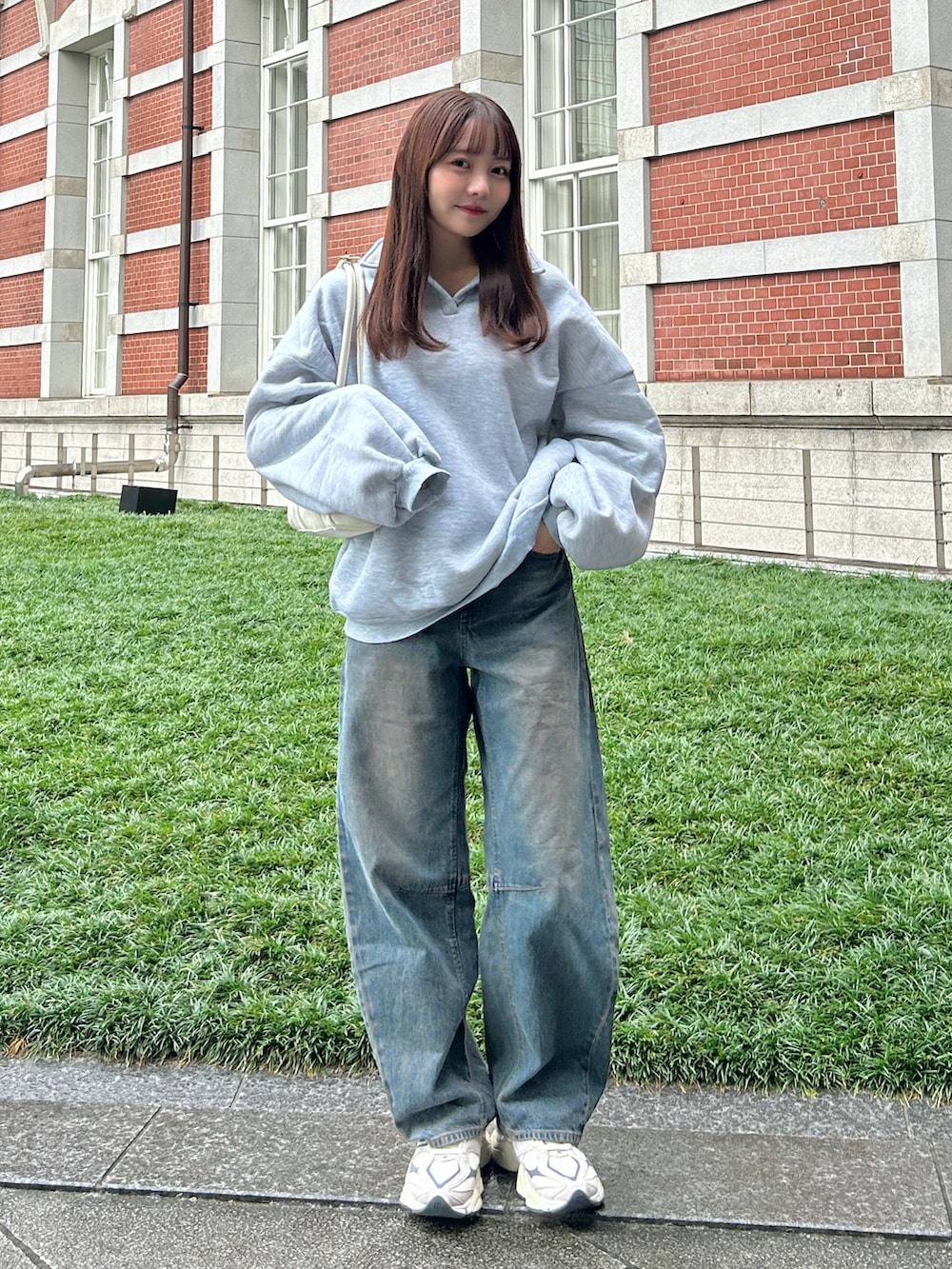 グレー系のスウェット、ブルー系のデニムパンツ、ベージュ系のスニーカーを着用したレディースの秋コーディネートの5枚目の写真