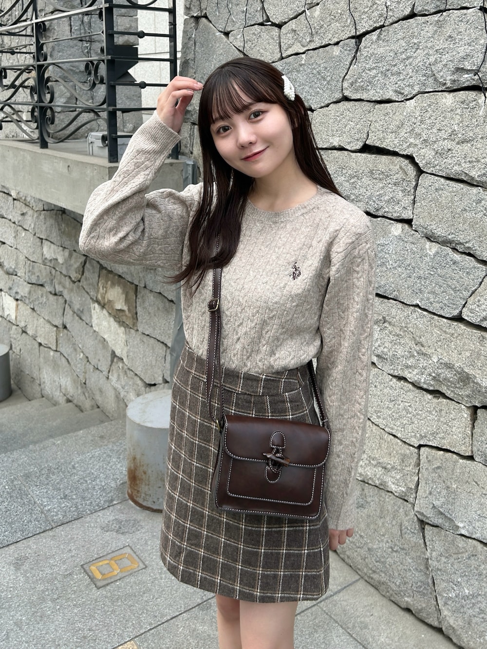 ベージュ系のニット/セーター、ブラウン系のショルダーバッグ、ブラウン系のスカートを着用したレディースの秋コーディネートの2枚目の写真