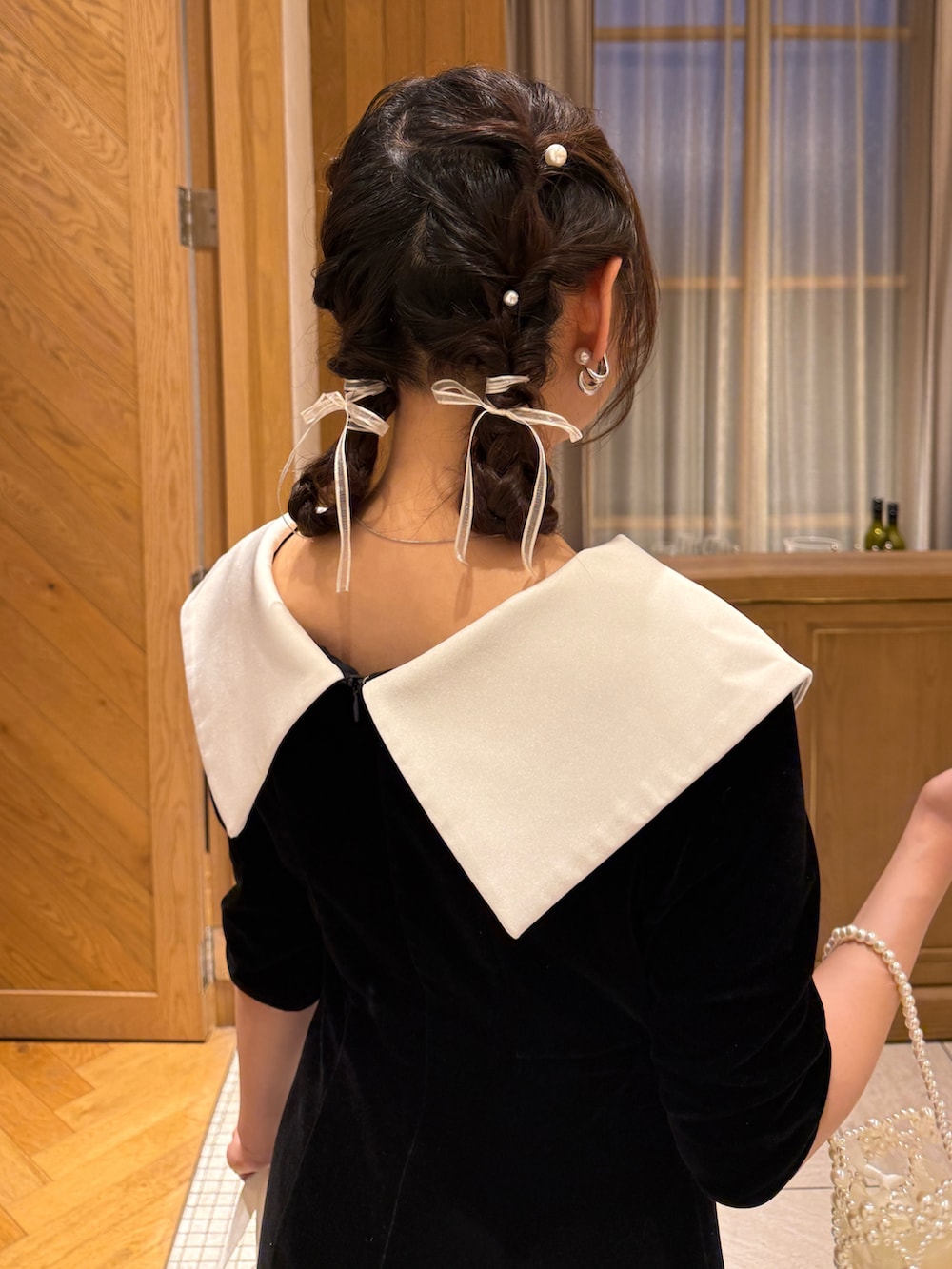 ブラック系のドレス、ブラック系のパンプス、ホワイト系のハンドバッグを着用したレディースの夏コーディネートの5枚目の写真