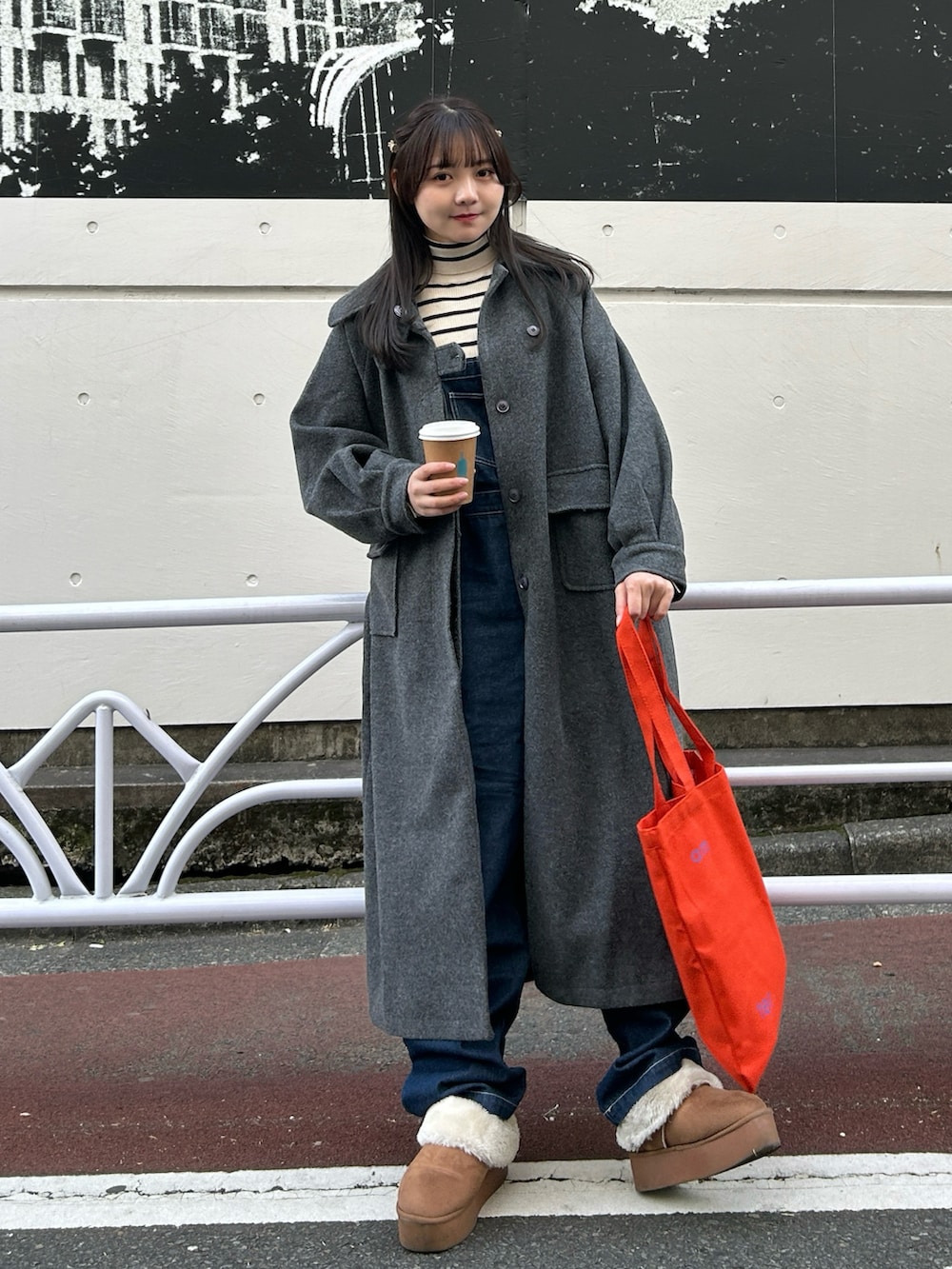 ブルー系のサロペット/オーバーオール、イエロー系のブーツ、ホワイト系のニット/セーターを着用したレディースの冬コーディネートの2枚目の写真