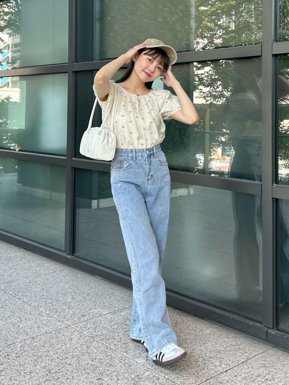 ブルー系のシャツ/ブラウス、ブルー系のデニムパンツ、ホワイト系のバッグを着用したレディースの夏コーディネートの2枚目の写真