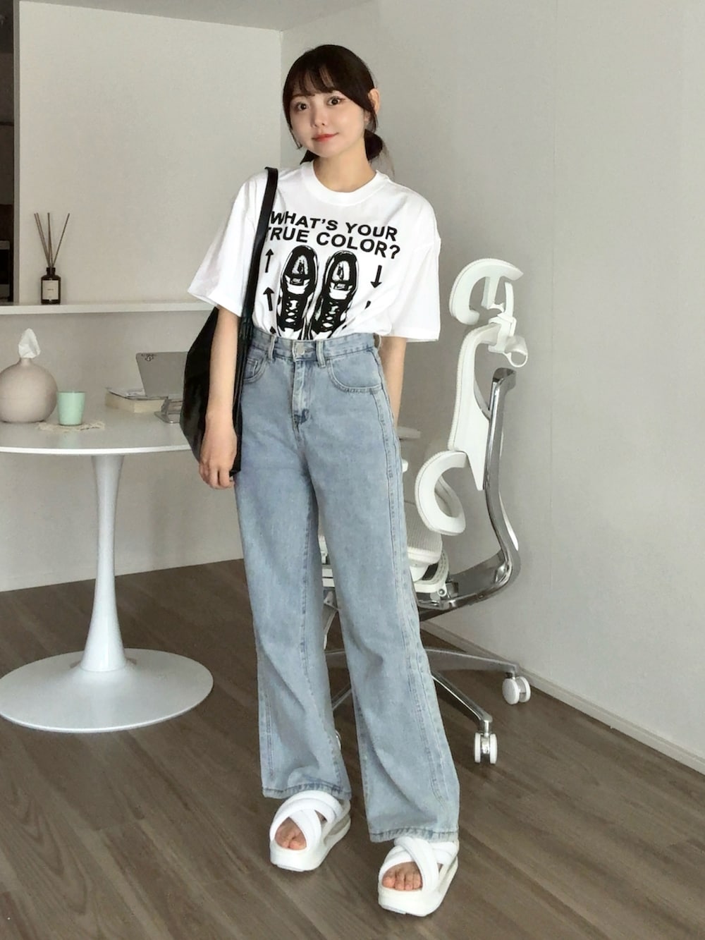 ブルー系のデニムパンツ、ホワイト系のTシャツ/カットソー、ブラック系のバッグを着用したレディースの夏コーディネートの2枚目の写真