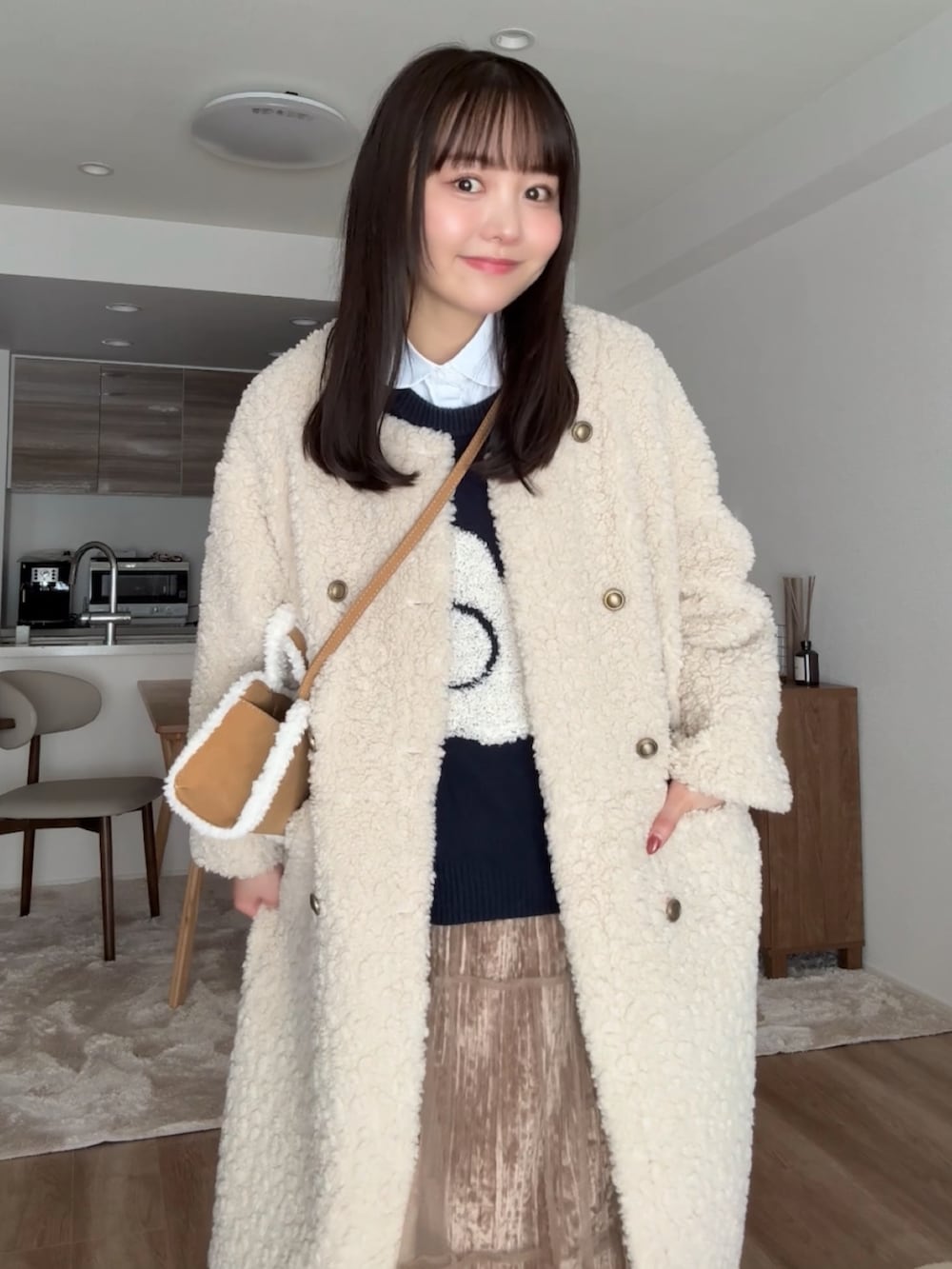 ブラウン系のブーツ、ベージュ系のその他アウター、ブラウン系のスカートを着用したレディースの冬コーディネートの2枚目の写真