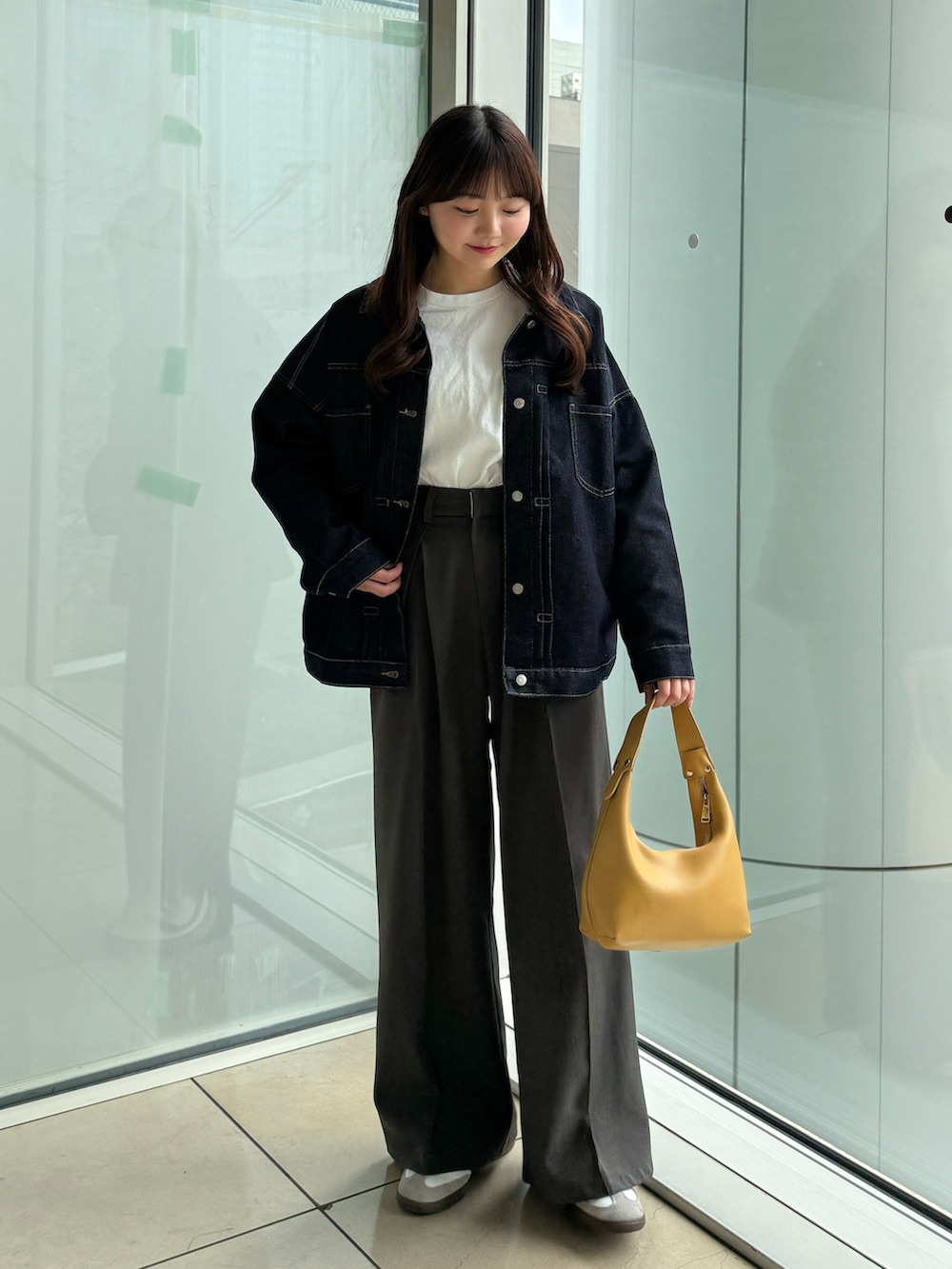 ホワイト系のTシャツ/カットソー、ブラック系のスラックス、ホワイト系のスニーカーを着用したレディースの春コーディネートの5枚目の写真