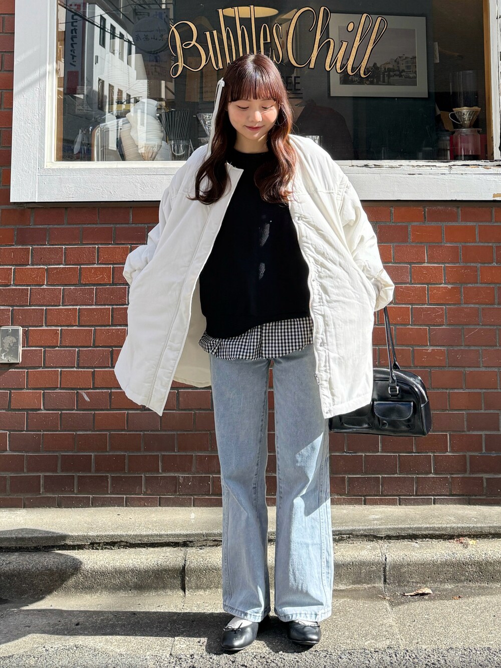 ブラック系のスウェット、ブラック系のショルダーバッグ、ホワイト系のトップスを着用したレディースの春コーディネートの2枚目の写真