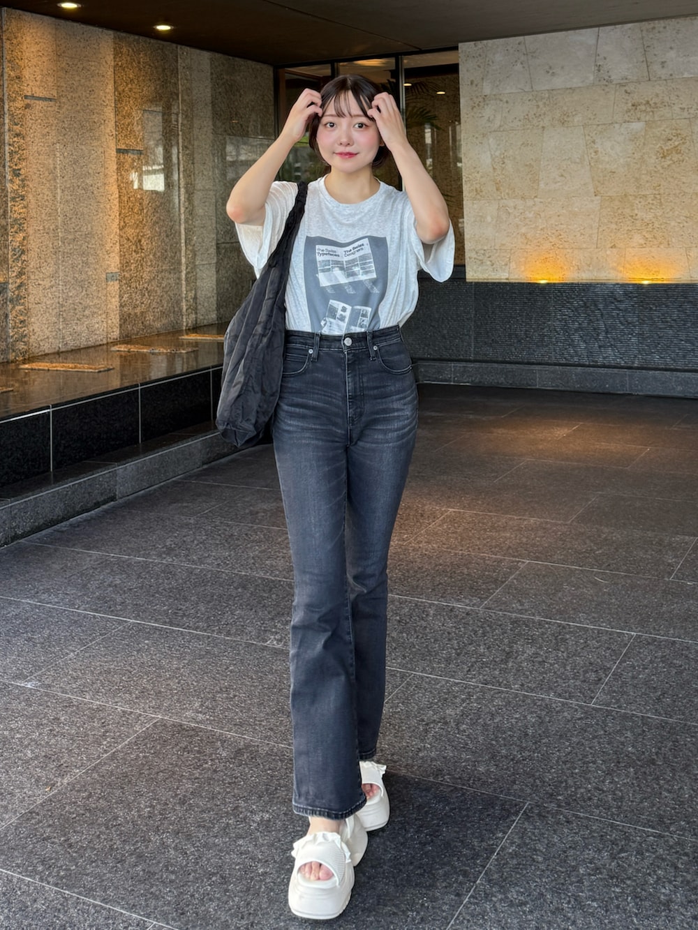 グレー系のTシャツ/カットソー、ブラック系のトートバッグ、ホワイト系のサンダルを着用したレディースの夏コーディネートの2枚目の写真