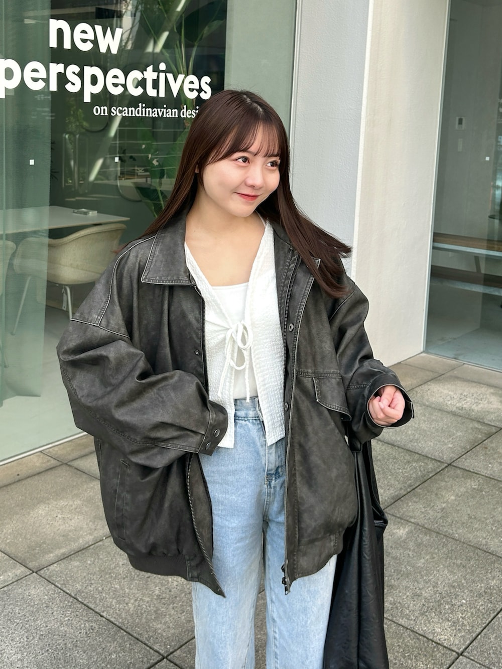 ブルー系のデニムパンツ、ブラック系のバッグ、ホワイト系のカーディガン/ボレロを着用したレディースの冬コーディネートの3枚目の写真