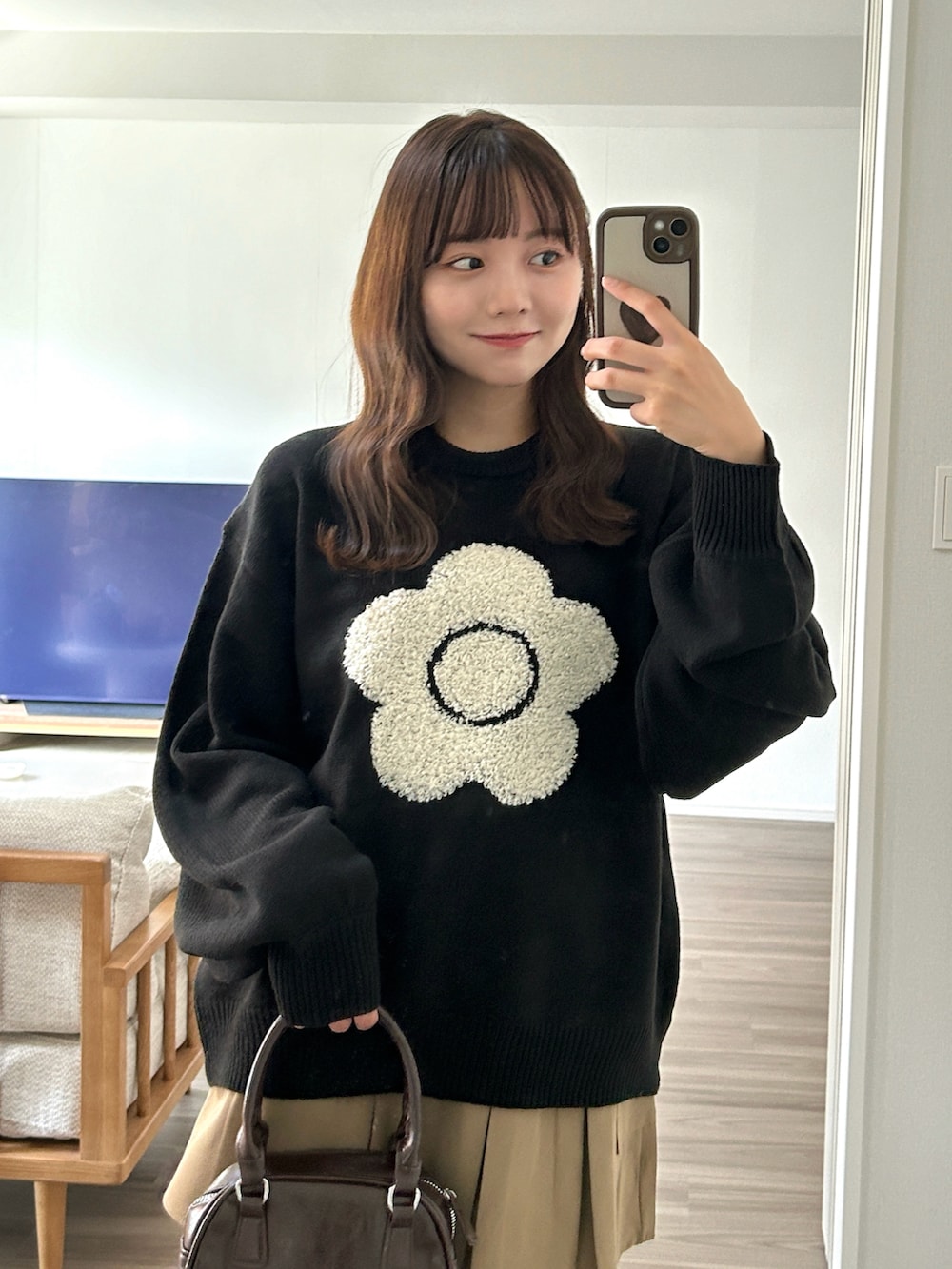 ブラウン系のハンドバッグ、ベージュ系のブーツ、ベージュ系のスカートを着用したレディースの秋コーディネートの4枚目の写真