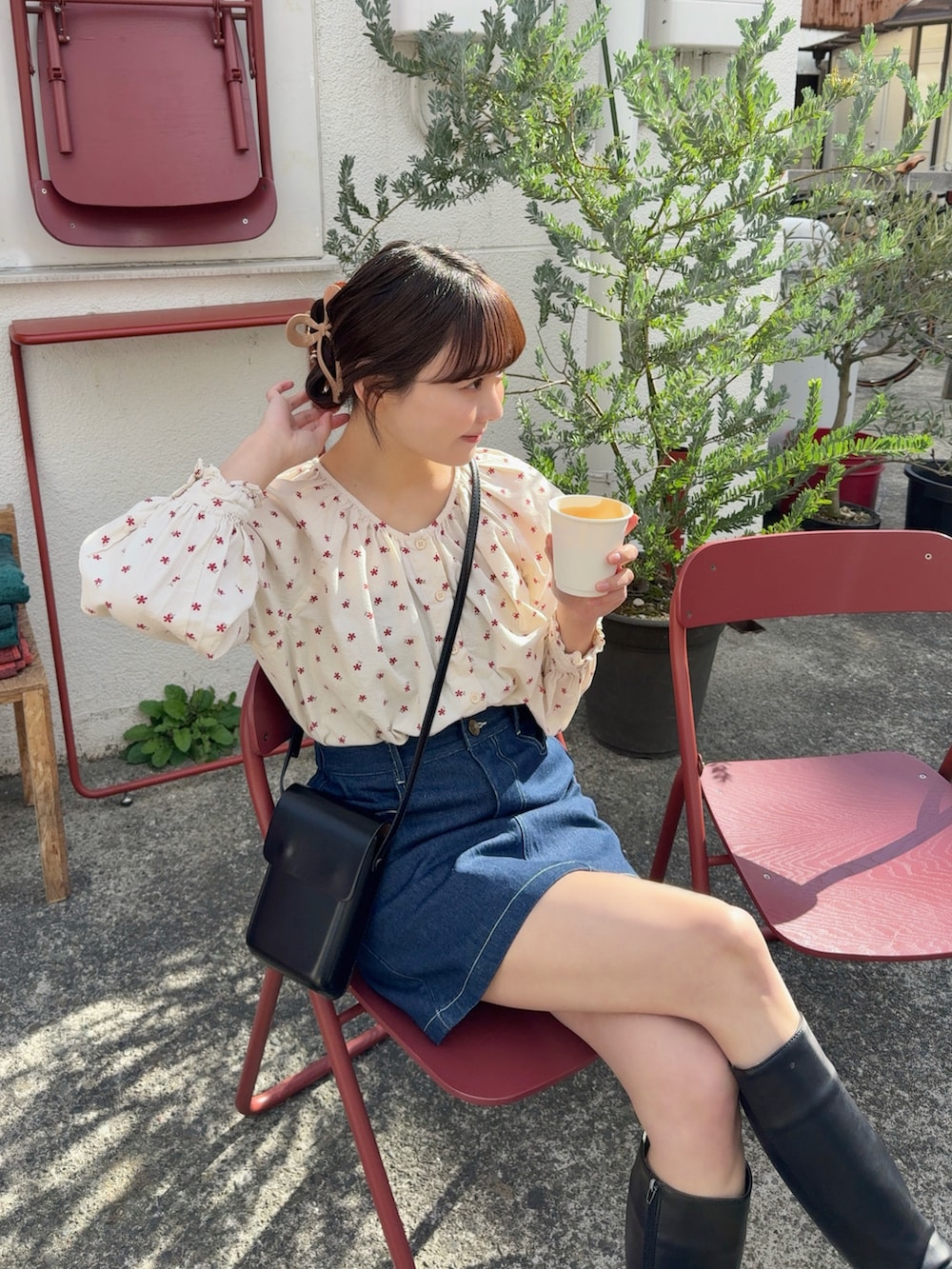 ブラウン系のピーコート、ブラック系のショルダーバッグ、ブラック系のブーツを着用したレディースの冬コーディネートの4枚目の写真