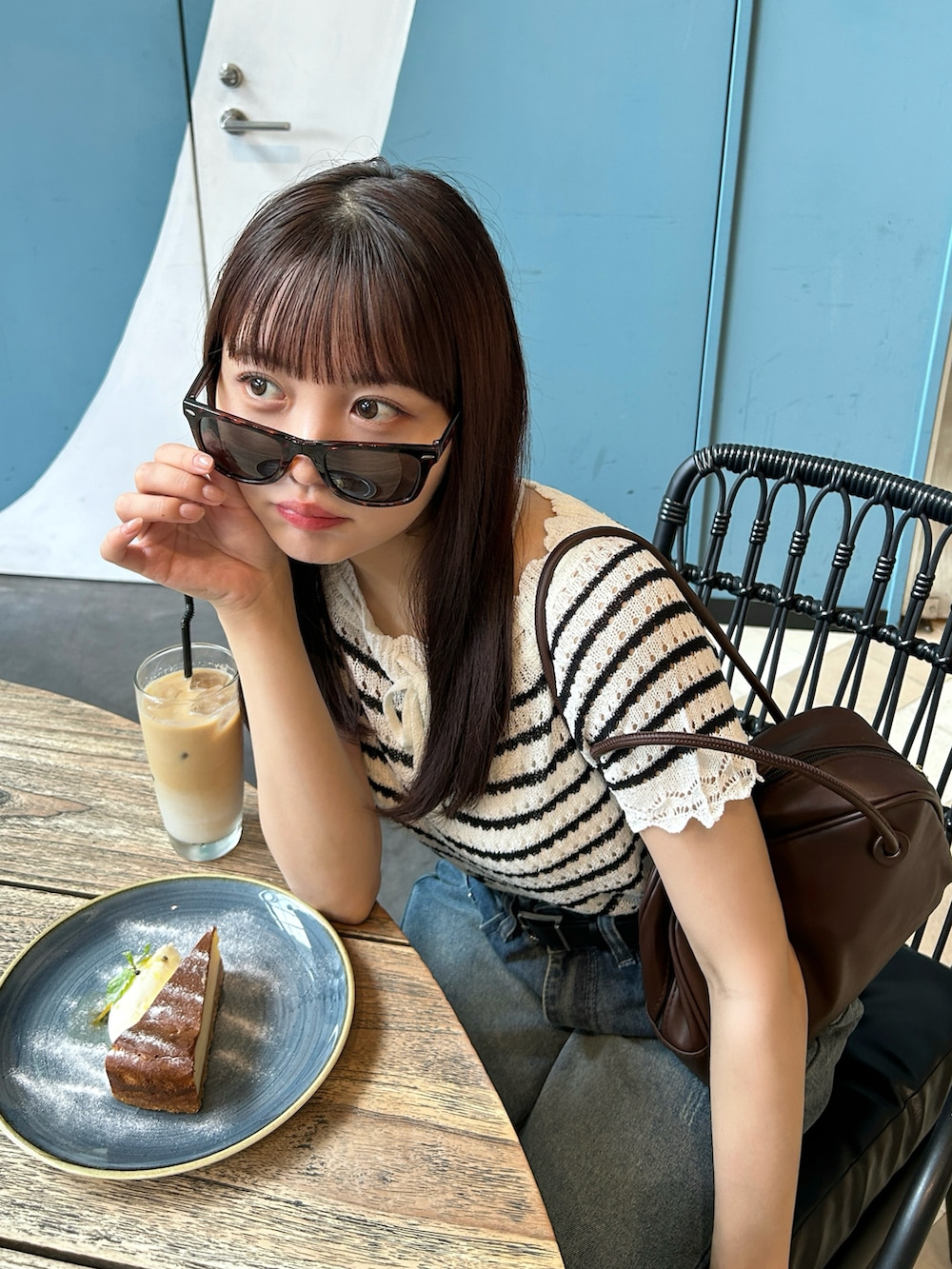 その他のニット/セーター、ブラウン系のバッグ、ブルー系のデニムパンツを着用したレディースの夏コーディネートの3枚目の写真