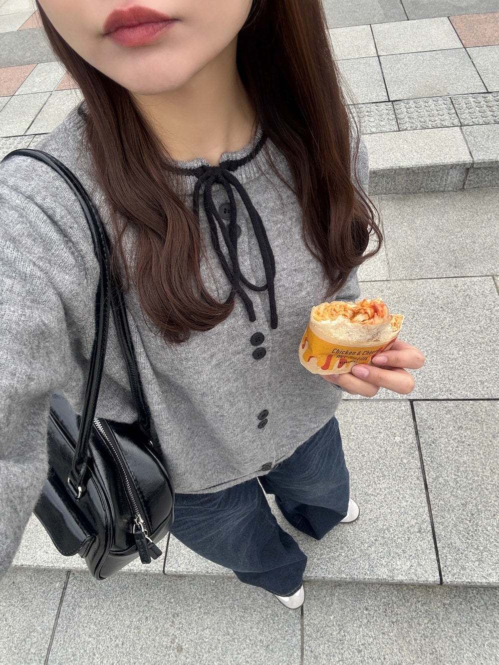 イエロー系のブーツ、ブラック系のダウンジャケット/コート、ブラック系のショルダーバッグを着用したレディースの冬コーディネートの3枚目の写真