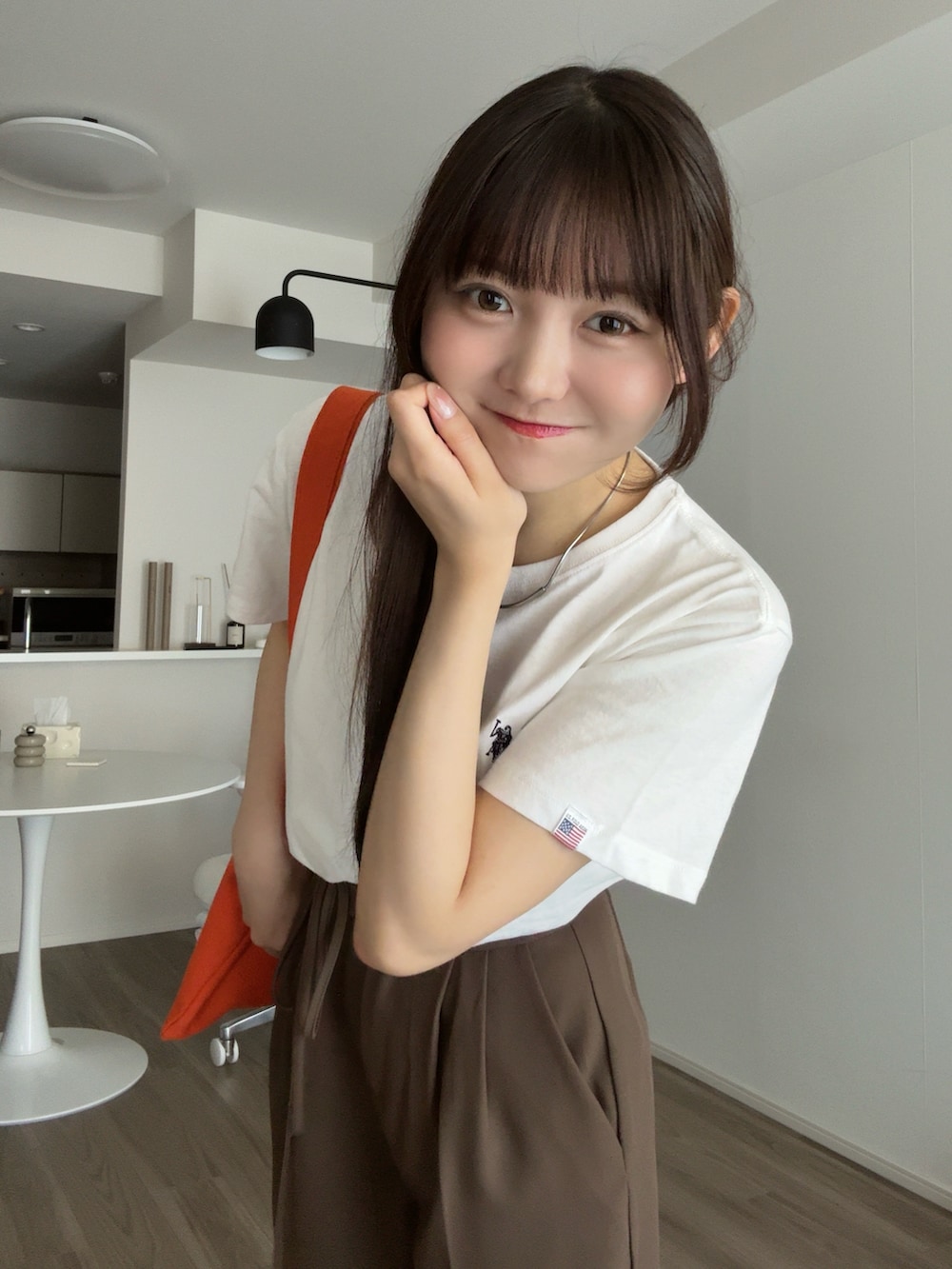 ホワイト系のTシャツ/カットソー、ブラウン系のその他パンツ、オレンジ系のトートバッグを着用したレディースの秋コーディネートの5枚目の写真