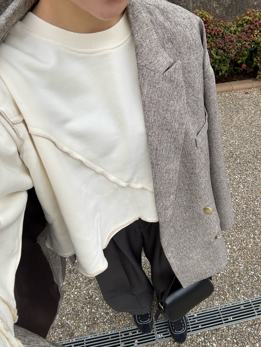 グレー系のスラックス、ホワイト系のスウェット、ベージュ系のテーラードジャケットを着用したレディースの春コーディネートの4枚目の写真