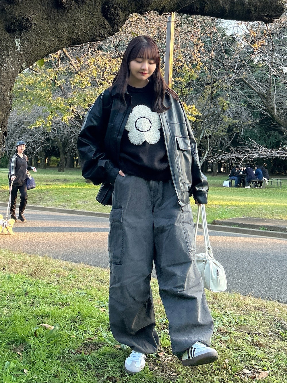 ホワイト系のバッグ、ブラック系のニット/セーター、グレー系のデニムパンツを着用したレディースの冬コーディネートの5枚目の写真