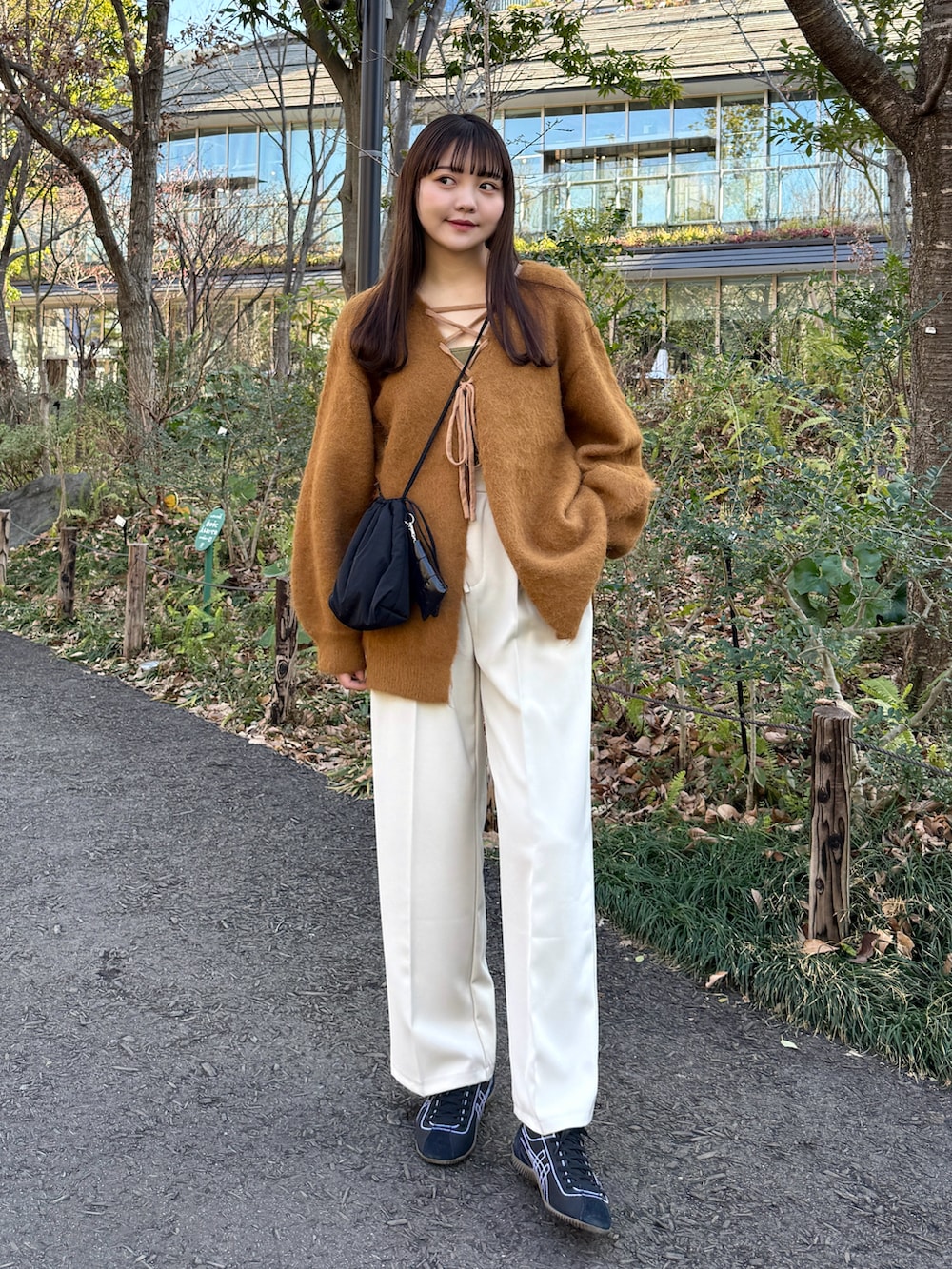イエロー系のカーディガン/ボレロ、ベージュ系のその他パンツ、ブラック系のスニーカーを着用したレディースの冬コーディネートの3枚目の写真