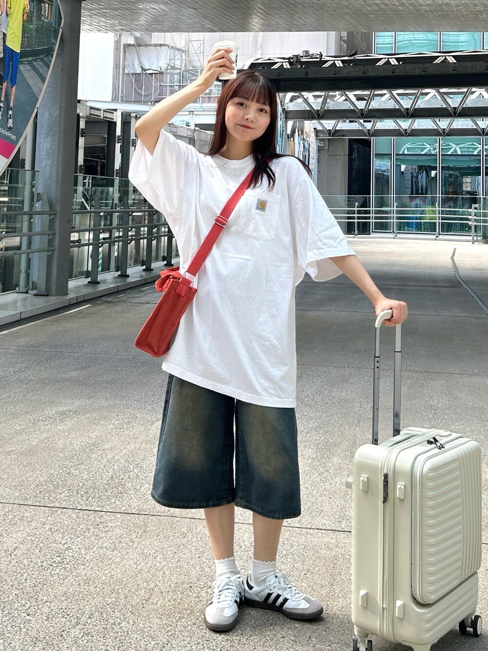 ホワイト系のTシャツ/カットソー、ブルー系のデニムパンツ、ホワイト系のスニーカーを着用したレディースの夏コーディネートの2枚目の写真