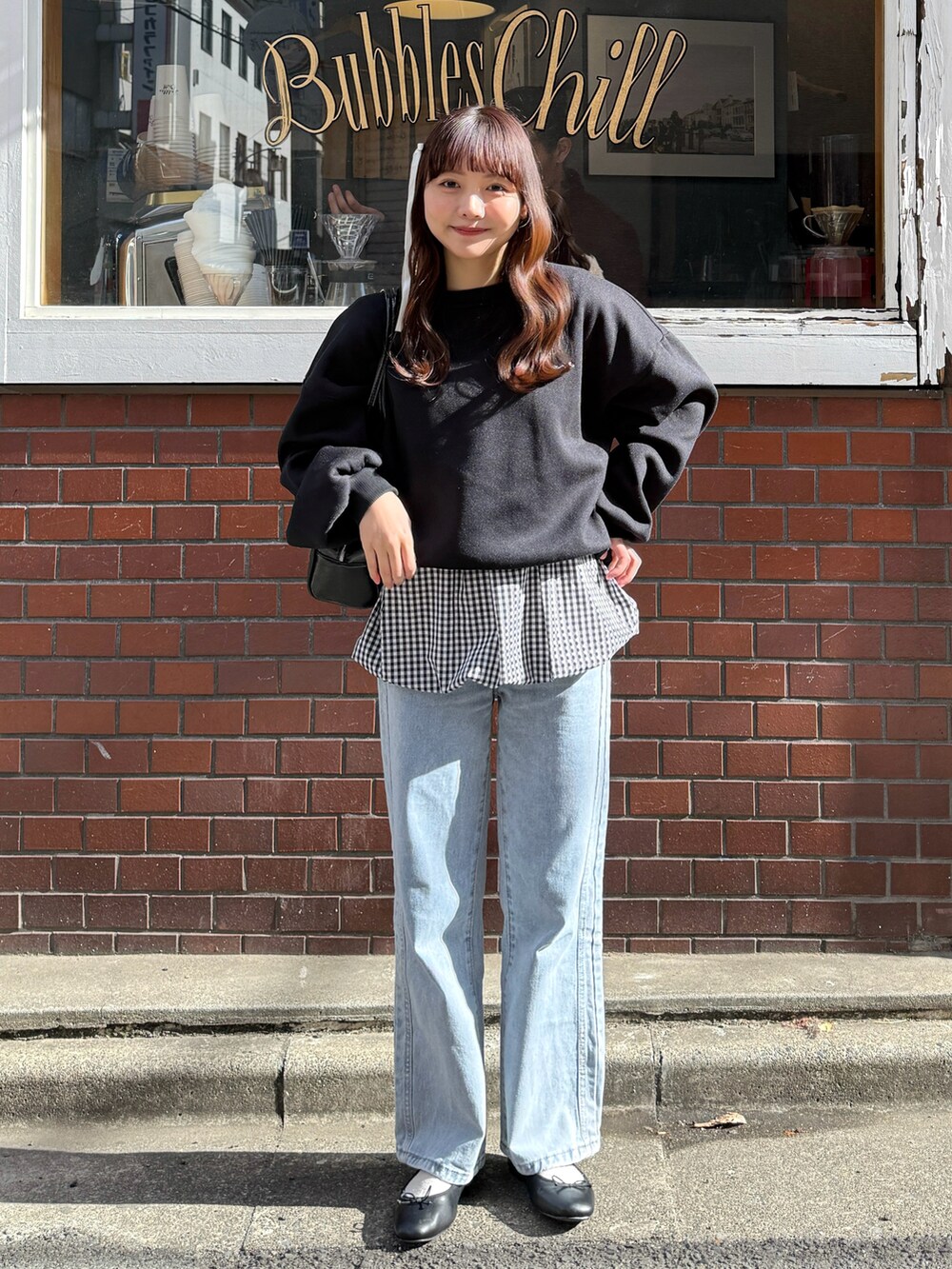 ブラック系のスウェット、ブラック系のショルダーバッグ、ホワイト系のトップスを着用したレディースの春コーディネートの5枚目の写真