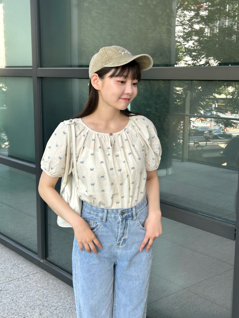 ブルー系のシャツ/ブラウス、ブルー系のデニムパンツ、ホワイト系のバッグを着用したレディースの夏コーディネートの4枚目の写真