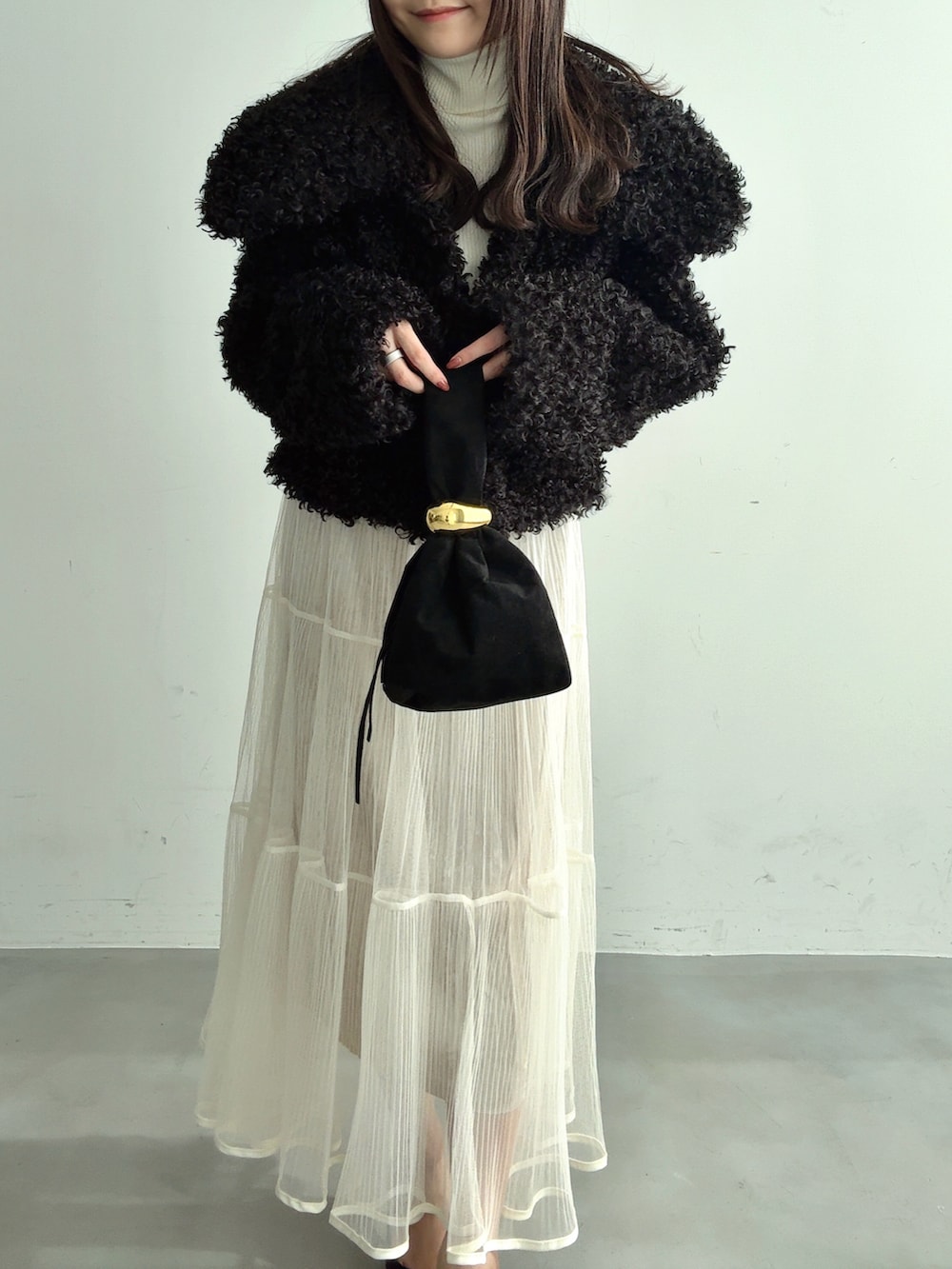 ホワイト系のTシャツ/カットソー、ブラック系のブルゾン、ホワイト系のスカートを着用したレディースの冬コーディネートの2枚目の写真