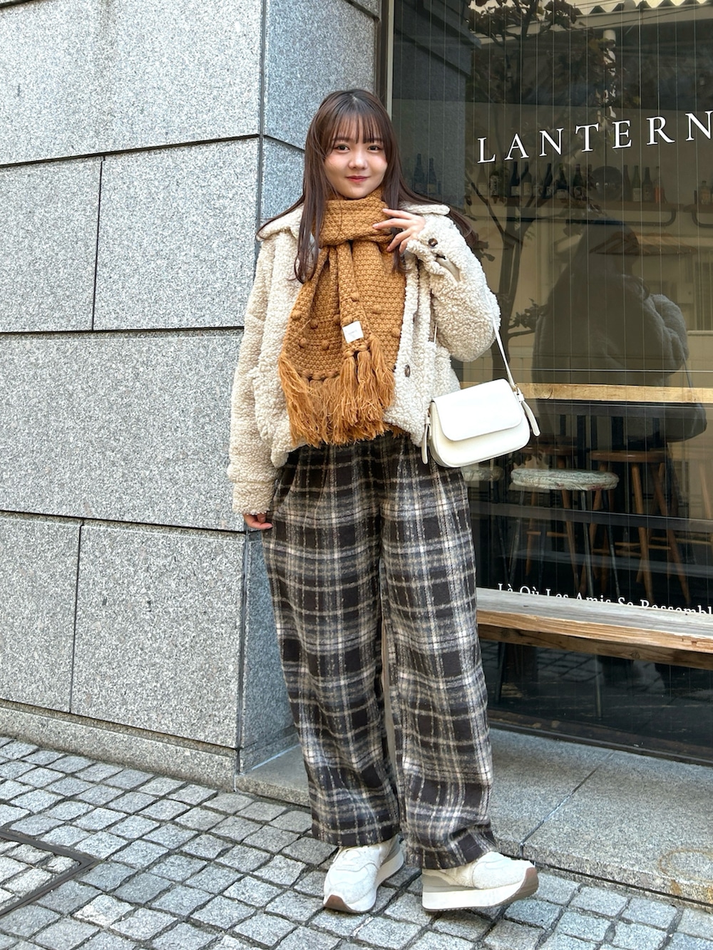 ホワイト系のハンドバッグ、ブラウン系のその他パンツ、ホワイト系のブルゾンを着用したレディースの冬コーディネートの4枚目の写真