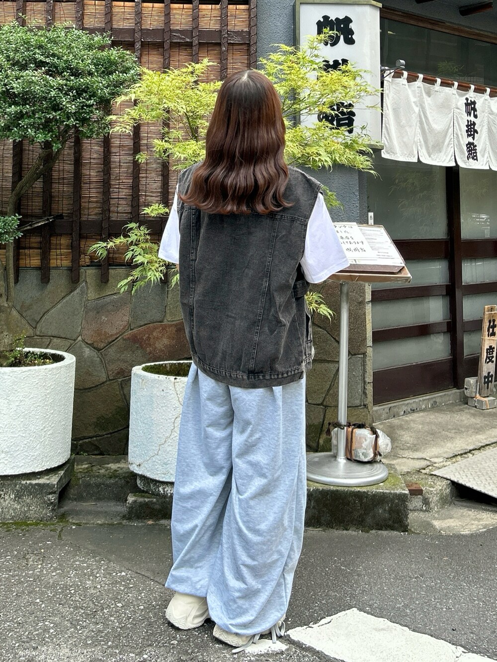 ホワイト系のスニーカー、ホワイト系のハンドバッグ、グレー系のスウェットパンツを着用したレディースの秋コーディネートの4枚目の写真