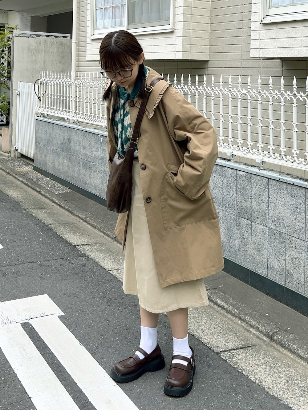 グリーン系のカーディガン/ボレロ、ブラウン系のショルダーバッグ、ホワイト系のスカートを着用したレディースの春コーディネートの3枚目の写真