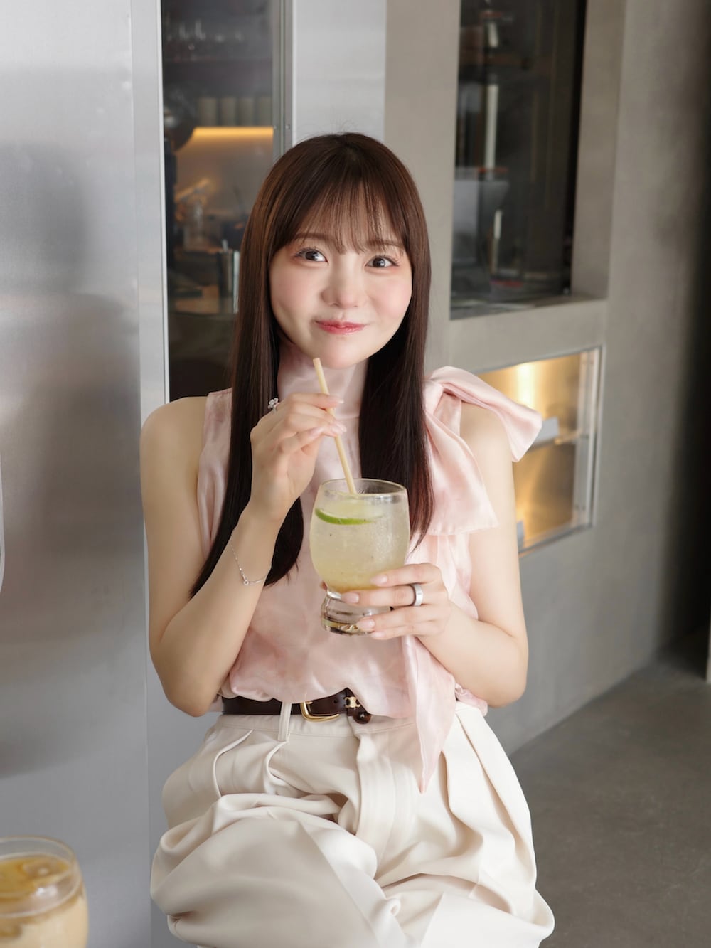 ホワイト系のサンダル、ピンク系のシャツ/ブラウス、ホワイト系のスラックスを着用したレディースの夏コーディネートの2枚目の写真